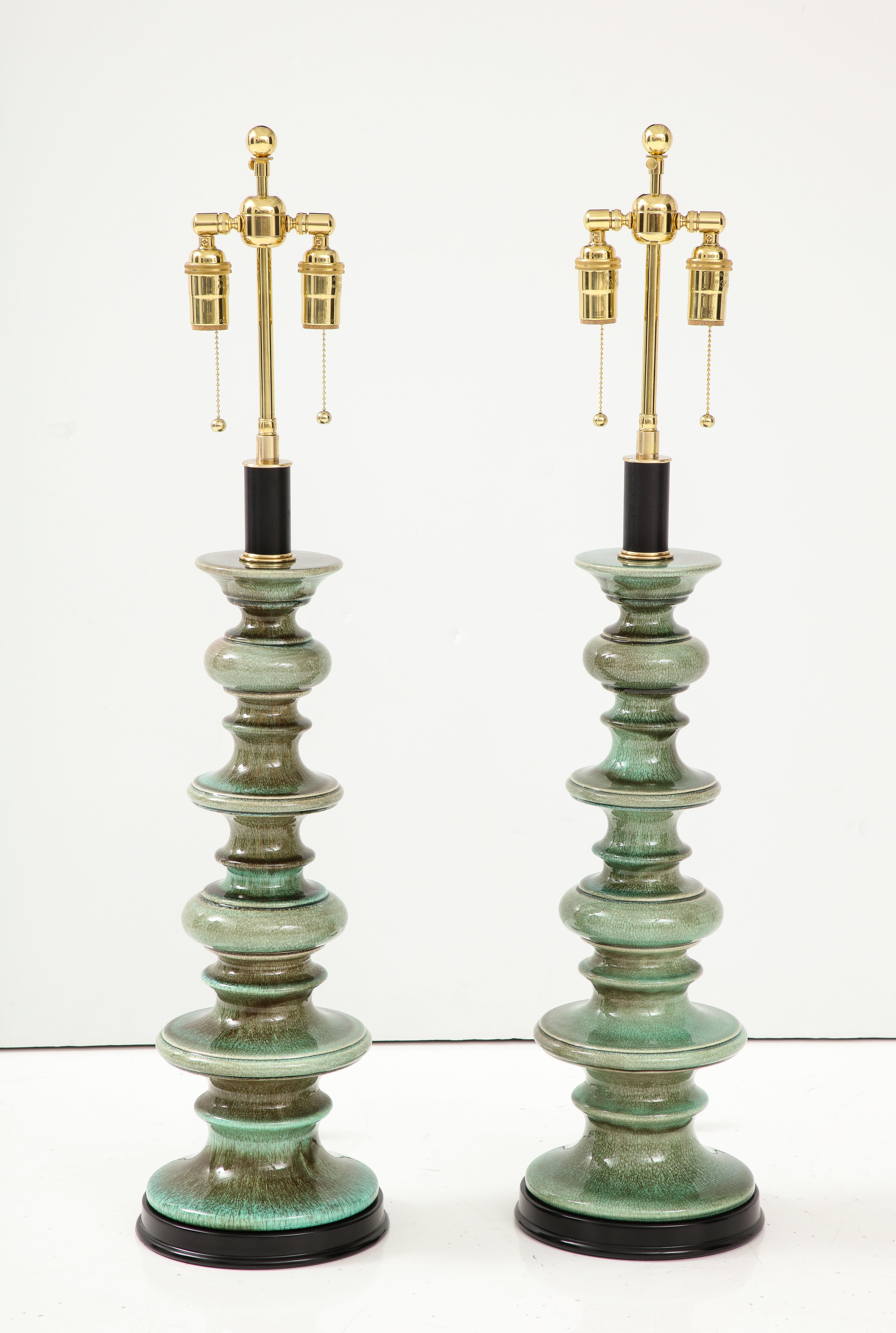 Pair of large ceramic lamps with a beautiful Jade Green crackle glaze finish.
The lamps have been Newly rewired with adjustable polished brass double clusters and silk rayon cords.
The lamps take standard size light bulbs and 60 watts per