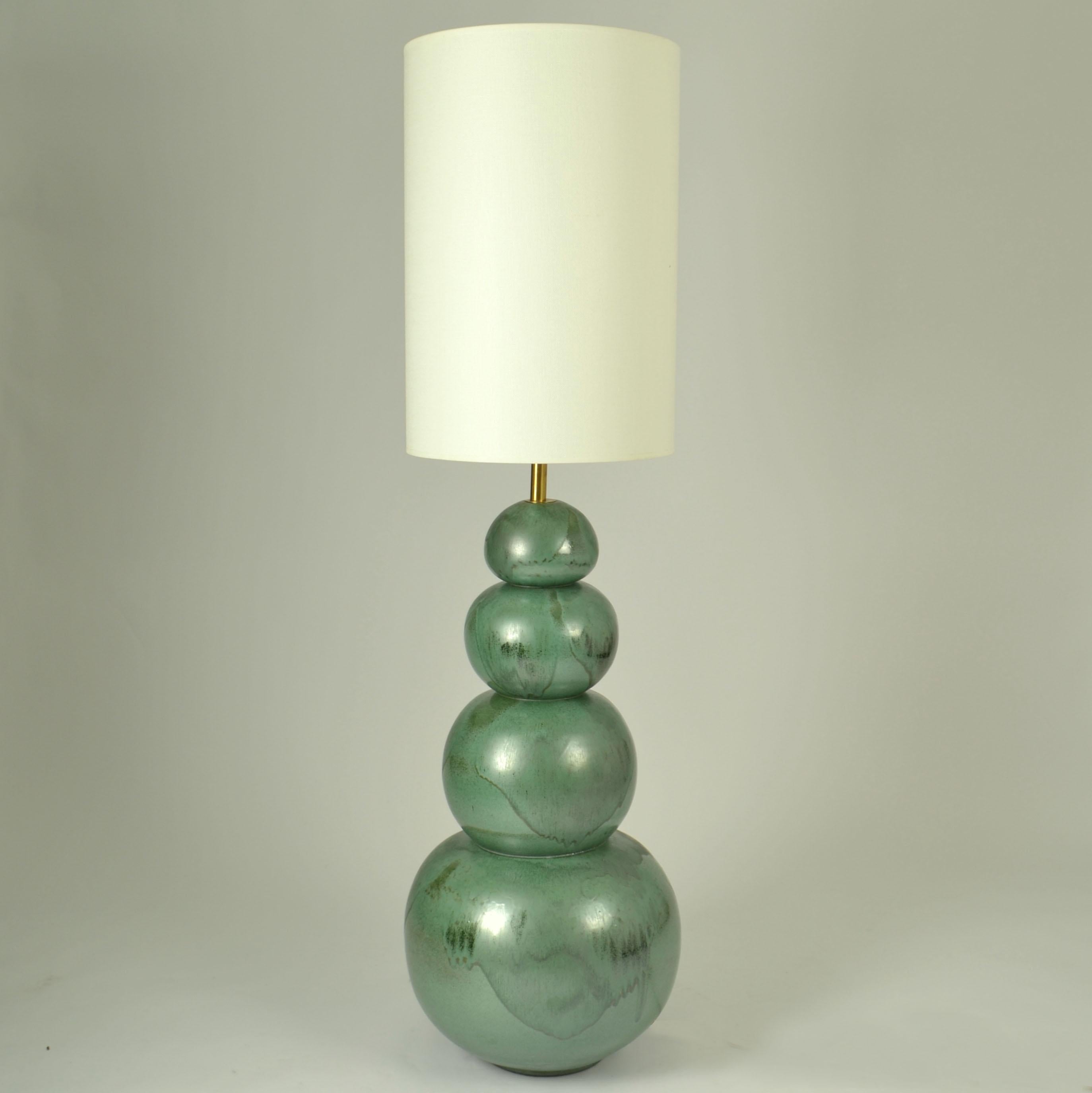 Paire d'extraordinaires grands lampadaires en céramique composés de quatre globes de taille décroissante et empilés les uns sur les autres pour former...  Lampadaire d'une taille étonnante. Ils sont coulés en une seule pièce et émaillés en bleu/vert