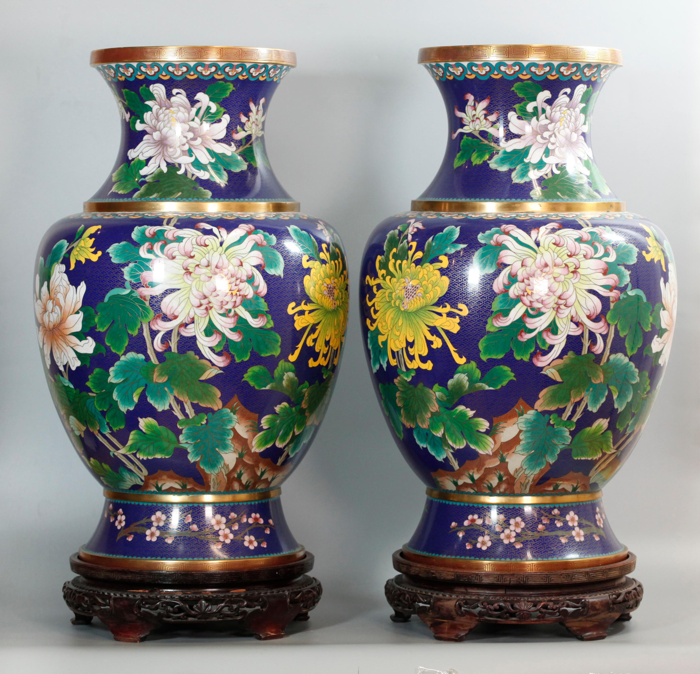 Motivo floral sobre fondo azul; las bases de madera se incluyen con estos jarrones; medidas totales aproximadas (con base): 28,75 pulgadas (alto) x 14 pulgadas (diámetro), jarrón solo (medidas aproximadas): 26 pulgadas (alto) x 14 pulgadas (diámetro)