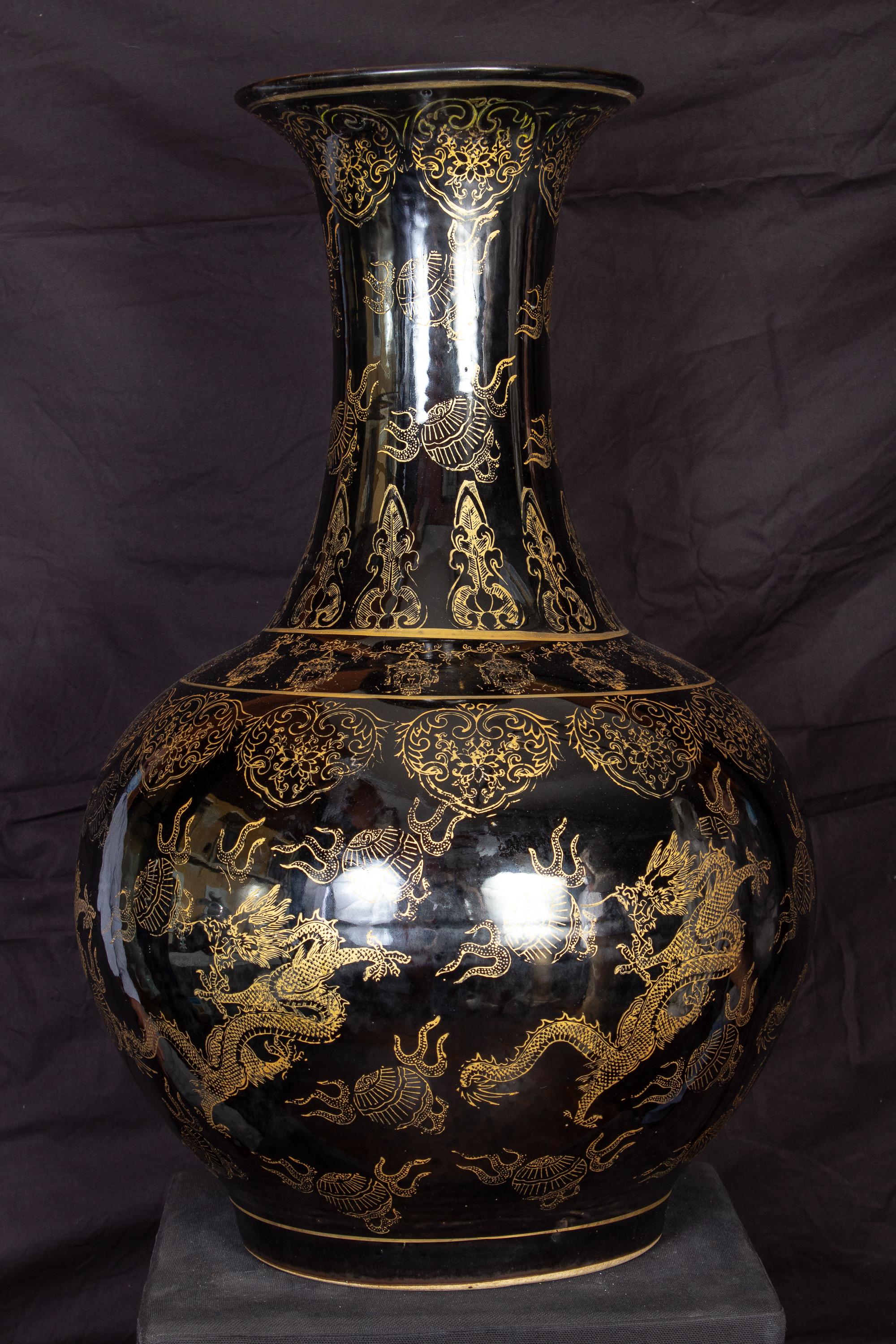 Elegant pair of huge Chinese vases. Each gold painted with a composite floral patterns and dragons.
These highly decorative Vases can also be uses as lamp bases. 
Measure: Height 60 cm.