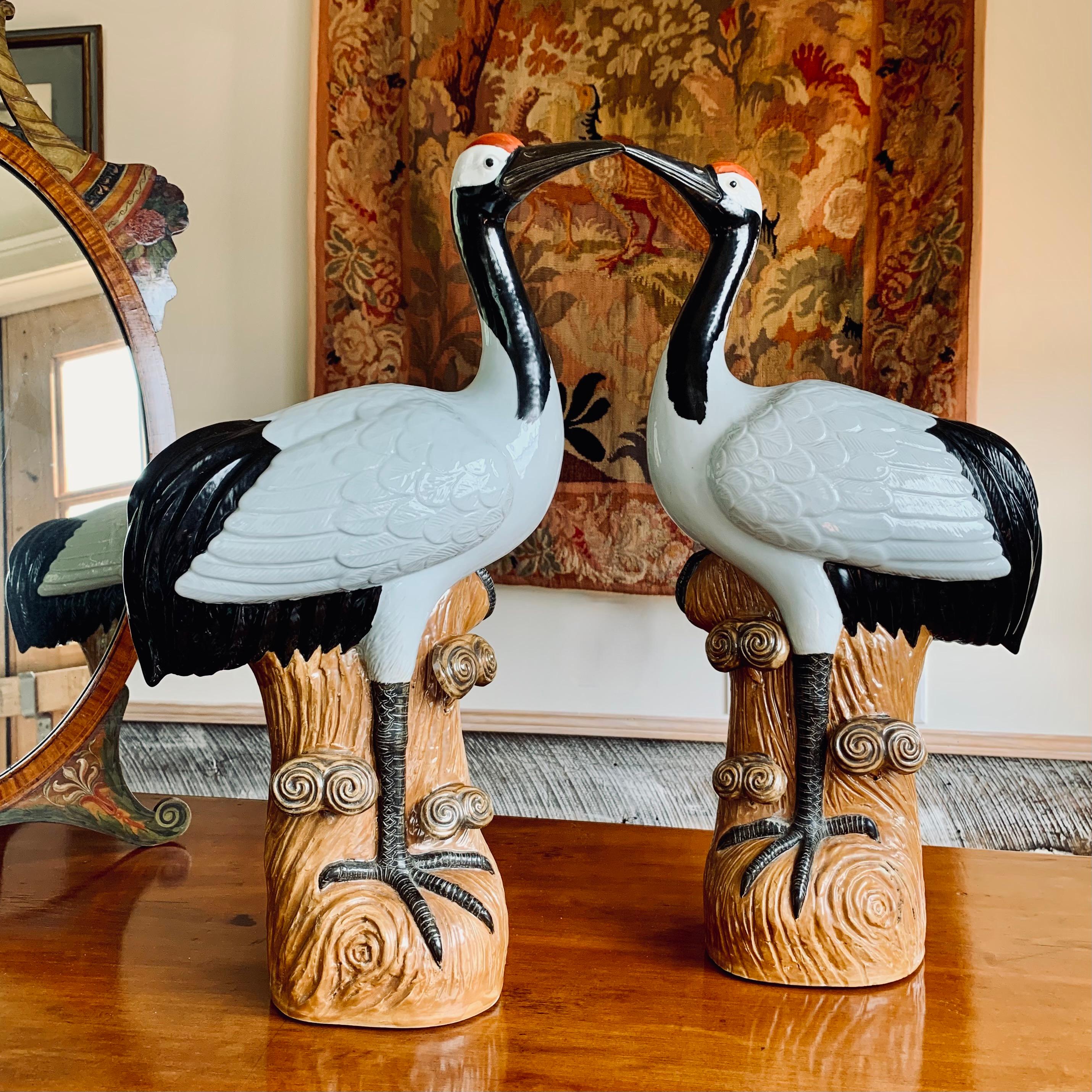 A large and striking pair of porcelain cranes, modeled in beautiful and precise detail: feathers, legs, the imaginative “wood” of the porcelain stumps they stand on are all exquisitely textured. The real red-crowned crane is a rare and very large