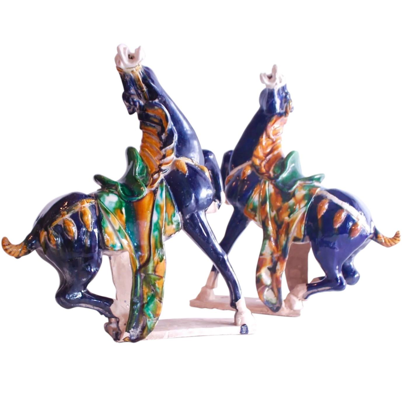 A magnificent and large pair of terra-cotta horses, saddled and caparisoned, glazed in the traditional Sancai colors of ochre, green and blue. A variety of auspicious and decorative pottery animals were traditionally made as architectural