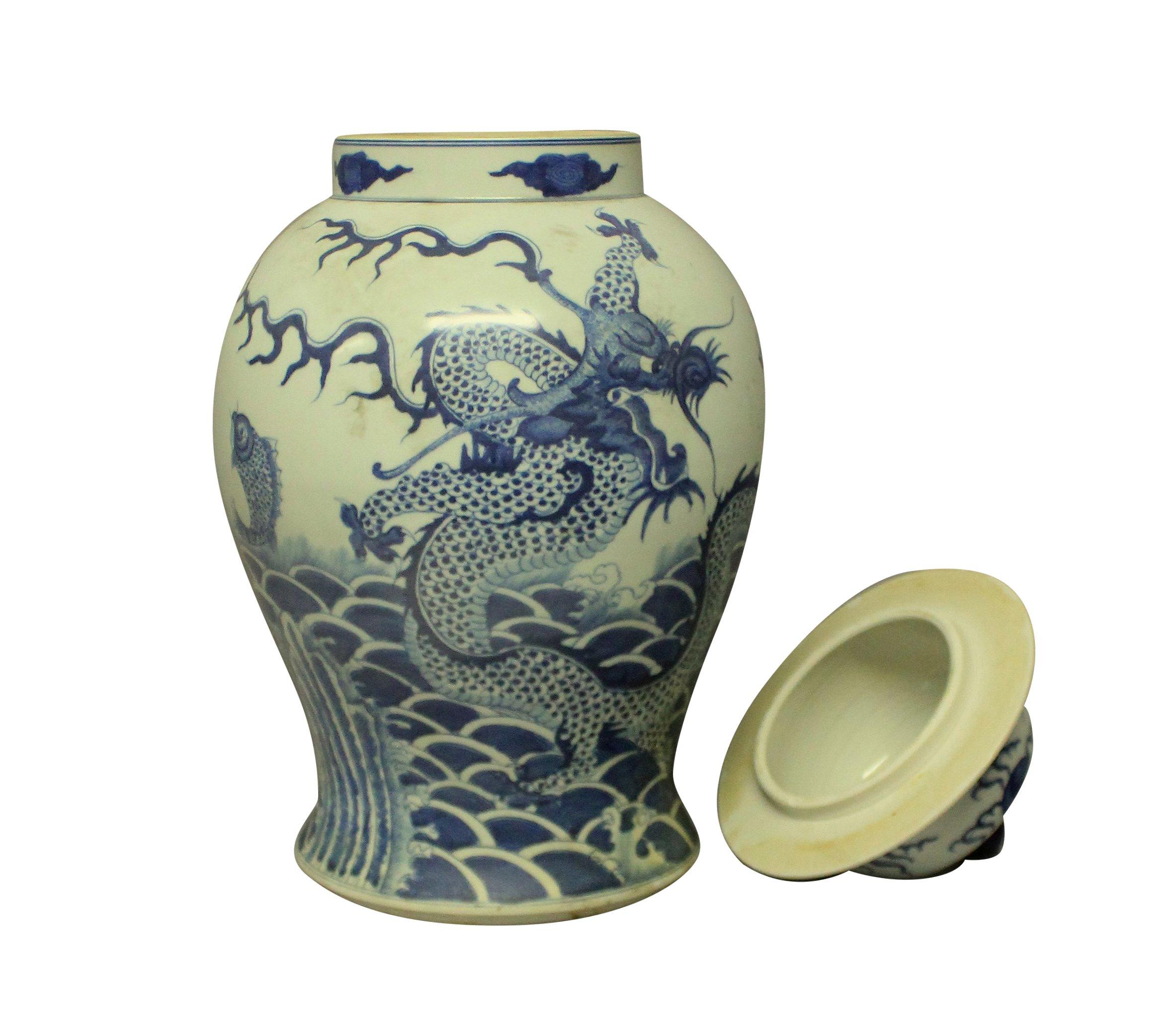 A pair of large hand painted blue and white Chinese vases with covers. Each depicting dragons and carp, the covers with finials.