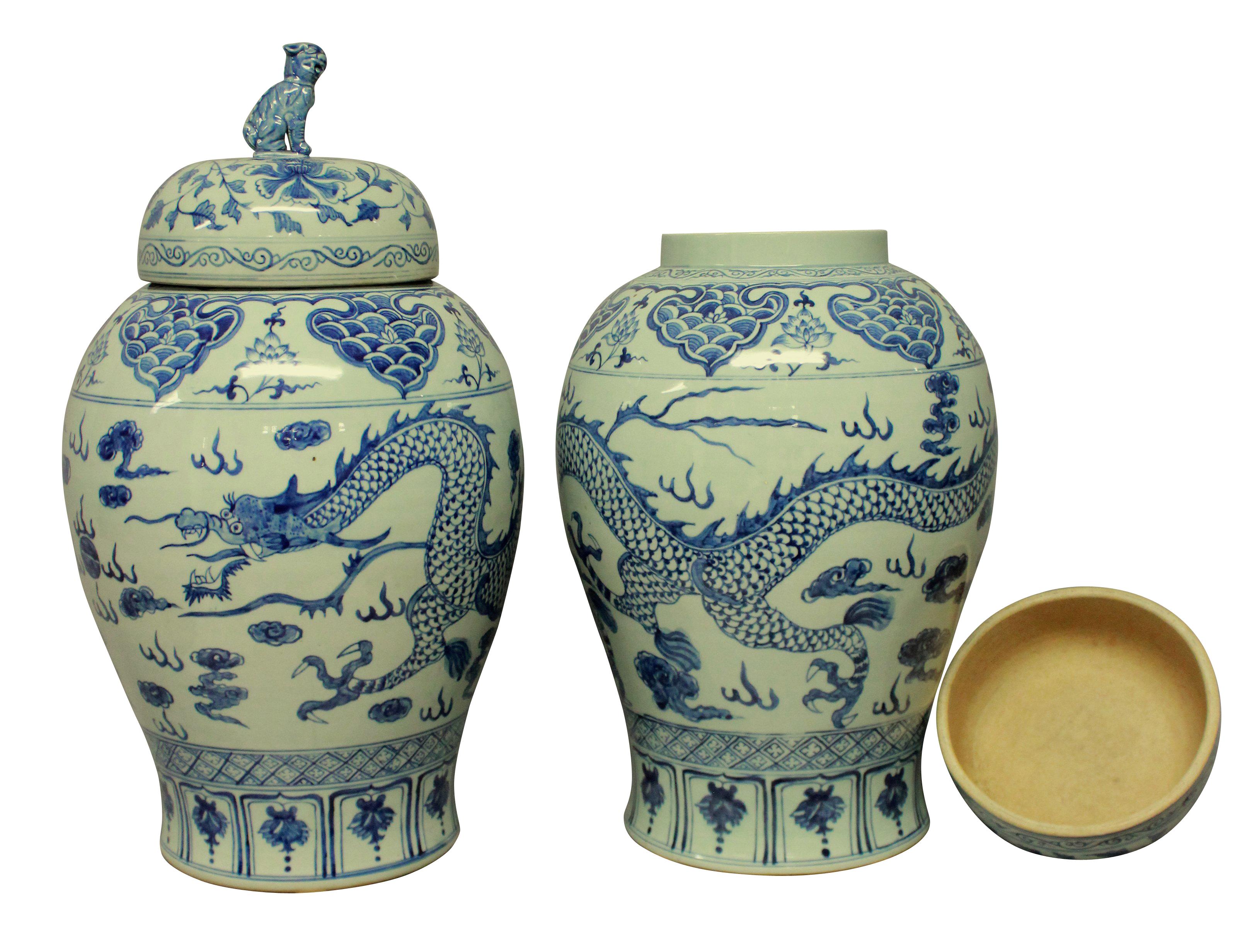 A pair of large hand painted blue and white Chinese vases with covers. Each depicting dragons and the covers with dog of foo finials.