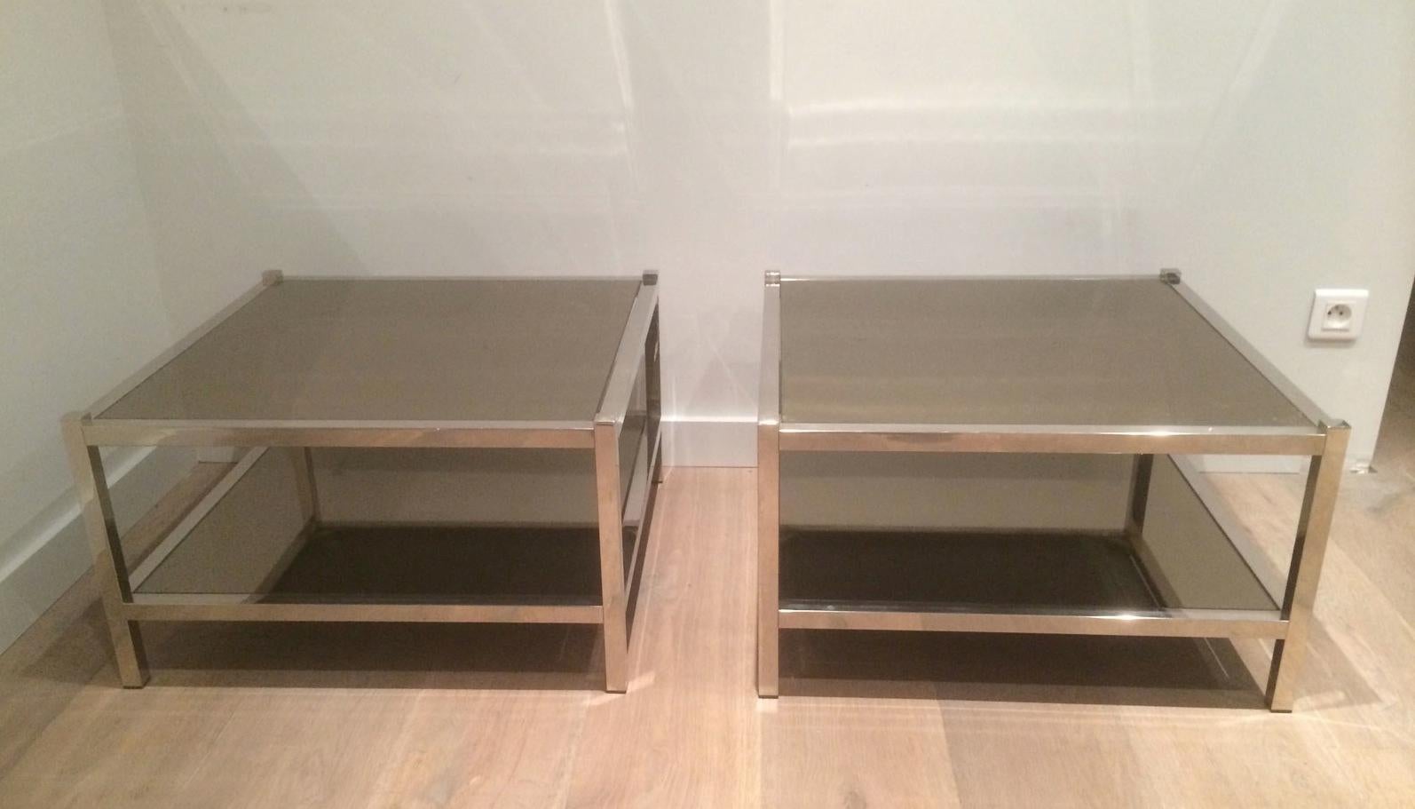 This nice pair of large side tables is made of chrome with bronze mirror shelves. This is a French work, circa 1970.