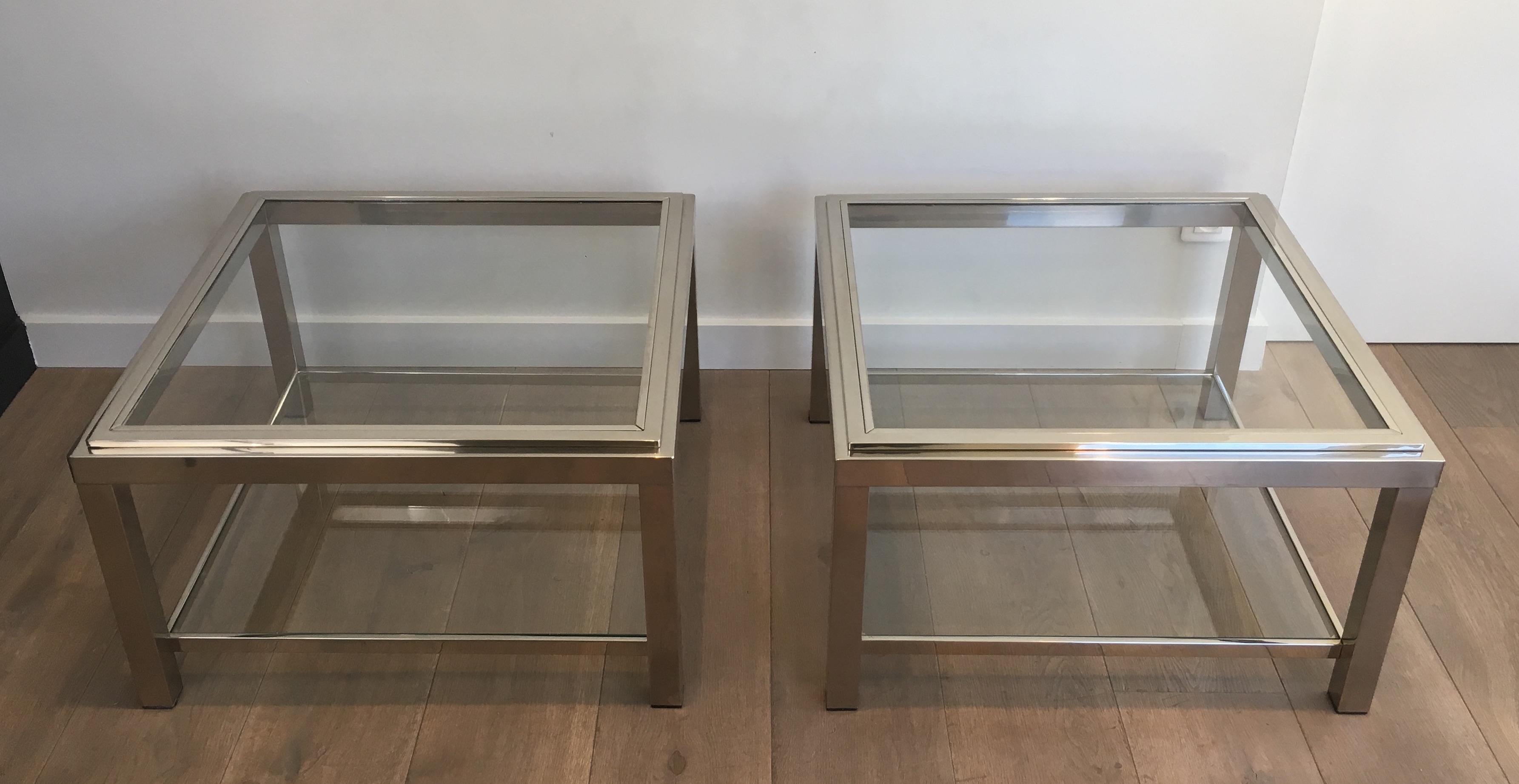 This pair of large side tables is made of chrome with glass shelves. This is a French work, circa 1970.