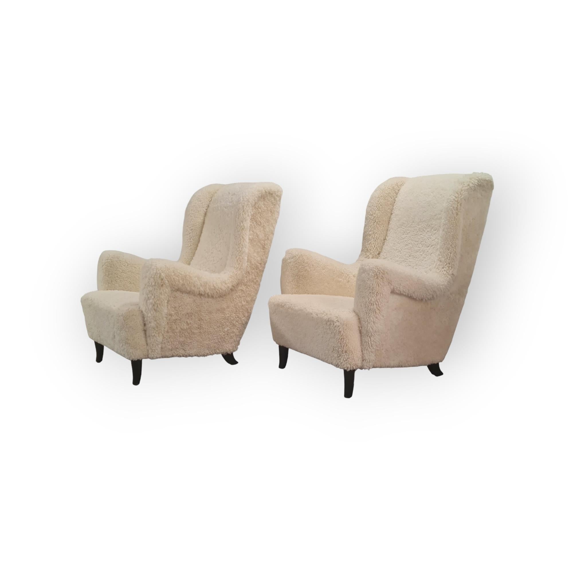 Milieu du XXe siècle Paire de grands et confortables fauteuils finlandais à dossier haut en peau de mouton blanc en vente