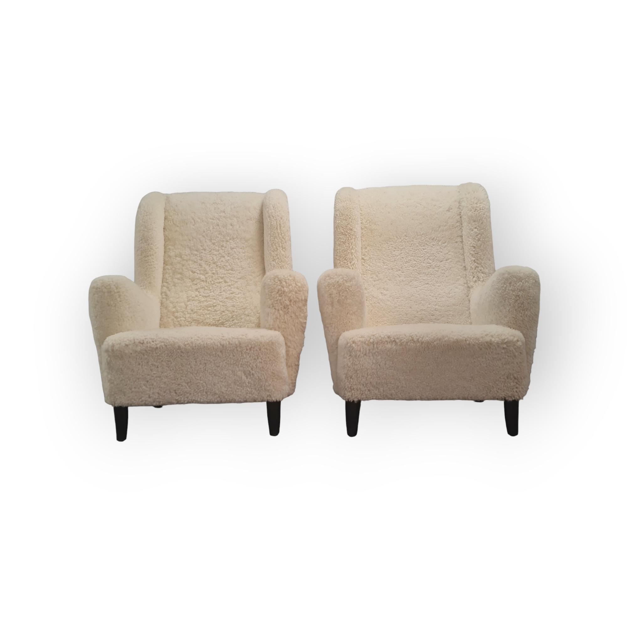 Cuir de mouton Paire de grands et confortables fauteuils finlandais à dossier haut en peau de mouton blanc en vente