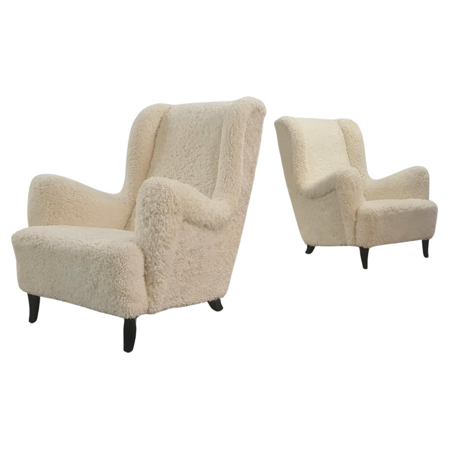 Paire de grands et confortables fauteuils finlandais à dossier haut en peau de mouton blanc en vente