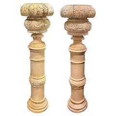 Coppia di grandi urne in marmo scolpite in stile continentale su piedistallo