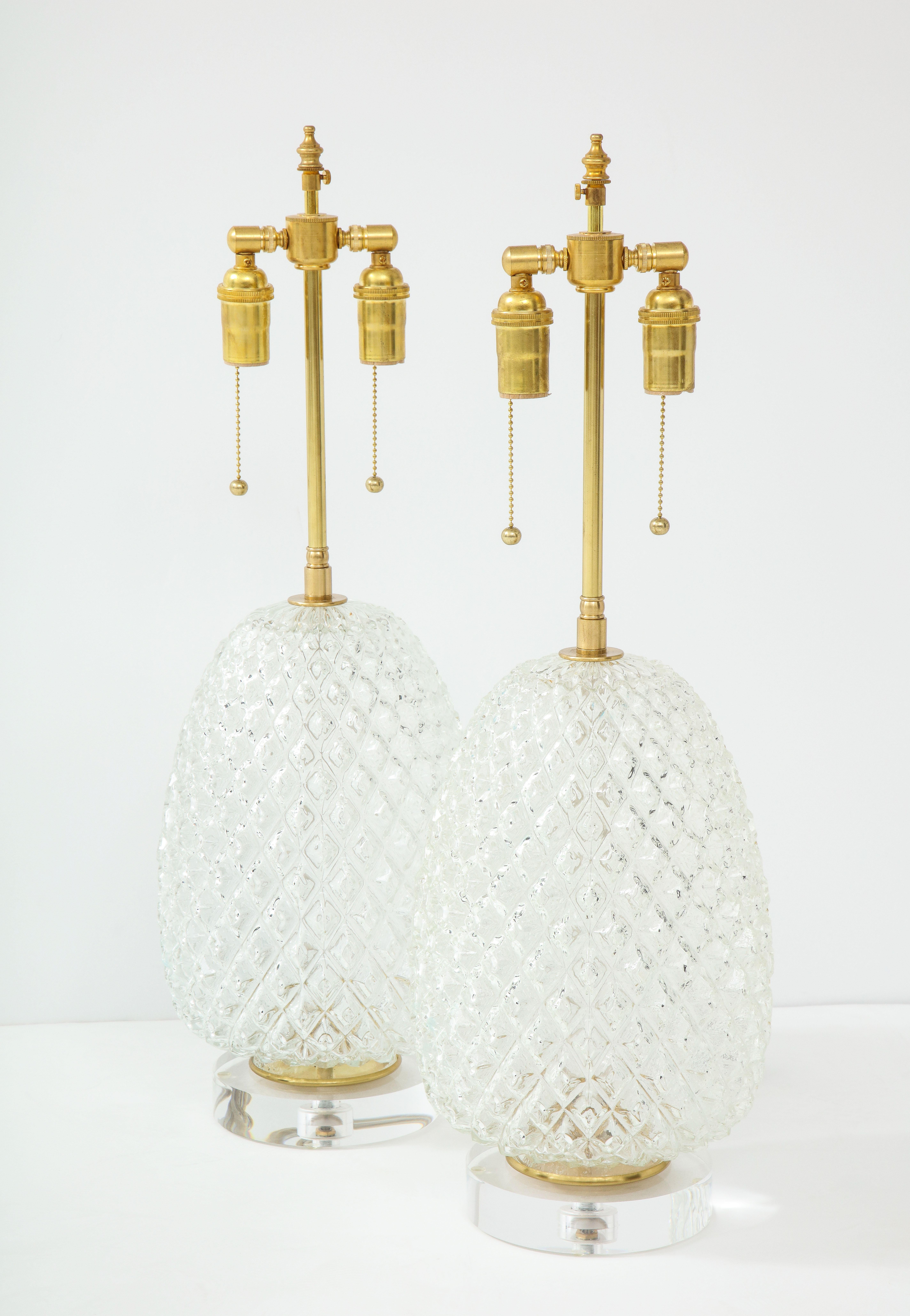 Pair of large cut glass pineapple lamps.
The glass lamp bodies sit on thick Lucite bases and they have been newly rewired
with adjustable brass double clusters that take standard size light bulbs.
The overall height is 27