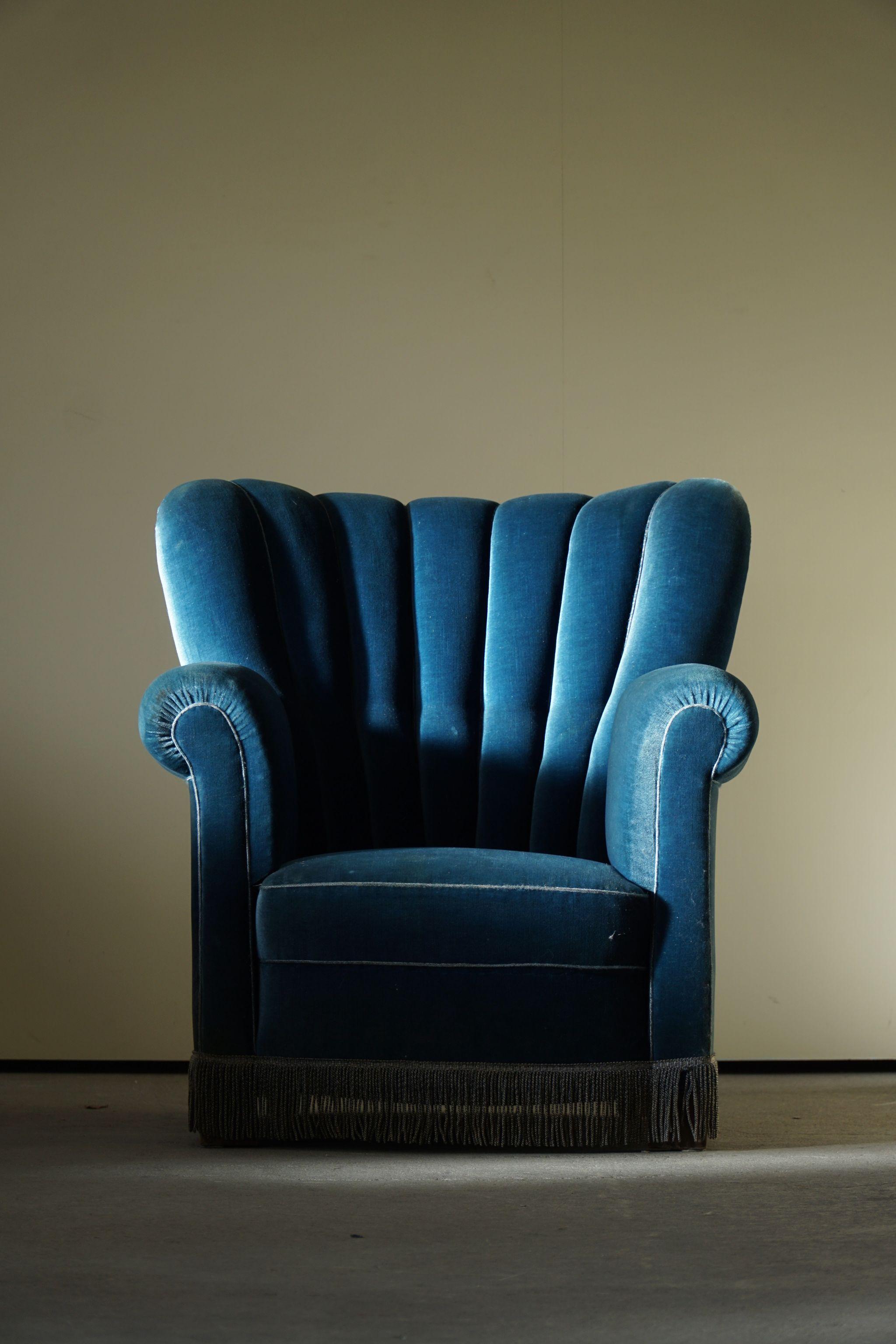 A comfortable pair of Art Deco lounge / club chairs upholstered in luxurious blue velvet. Made in 1940s by a Danish cabinetmaker. 

A nice curved pair in club chairs in the style of Fritz Hansen Model 1518.

