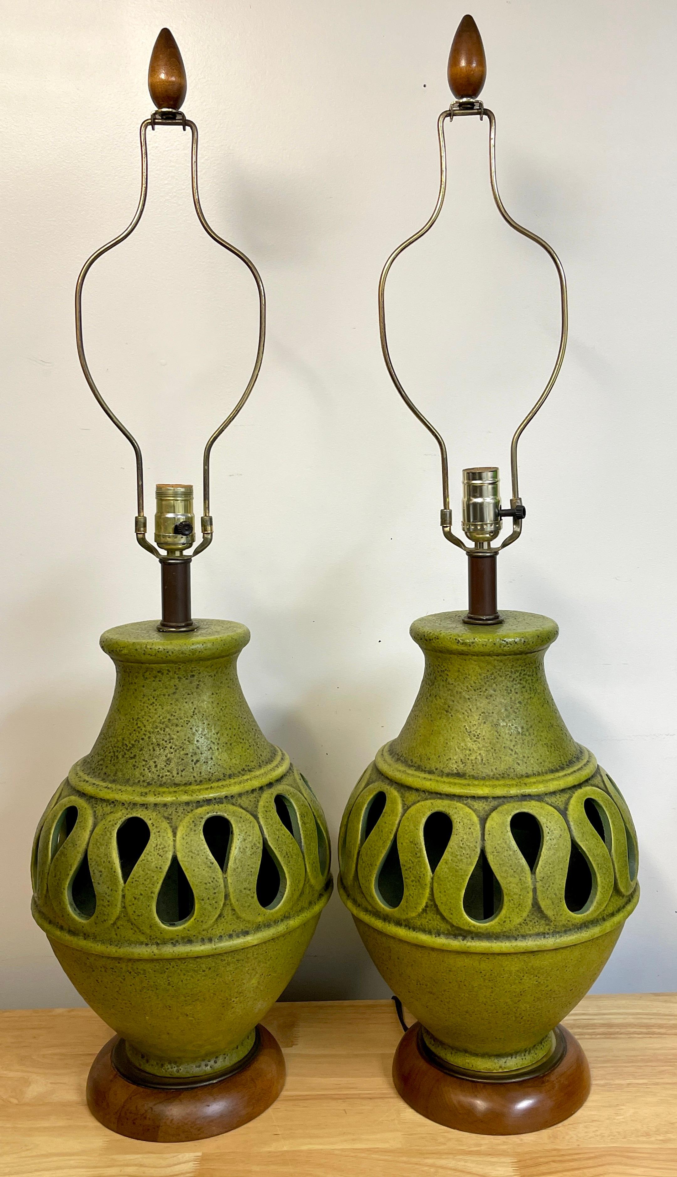 Pair of large Danish modern Green Monochrome Pottery Reticulated lamps
Each one with the original harp, teak wood finials and mounts. The beautiful monochrome green glaze vase with continuous undulating pierced center. Unmarked 
37