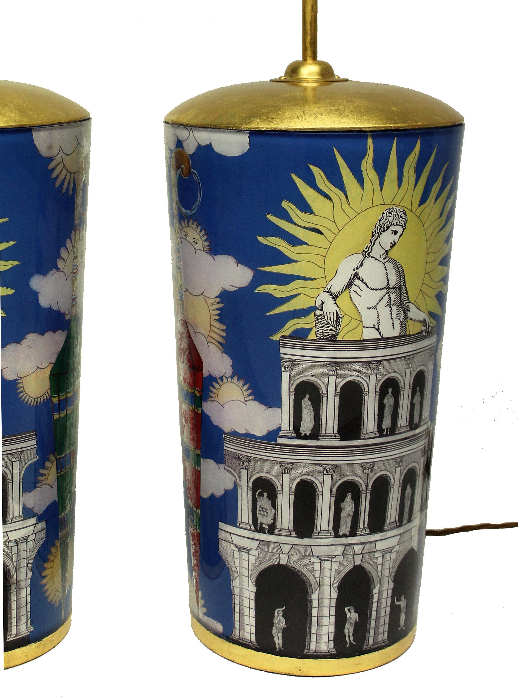 A pair of large hand painted églomisé glass table lamps inspired by Fornasetti. These lamps have been commissioned by Ebury trading and are limited to this pair only. The lamps are inspired by the 1950s designs of Pietro Fornasetti. They have wooden