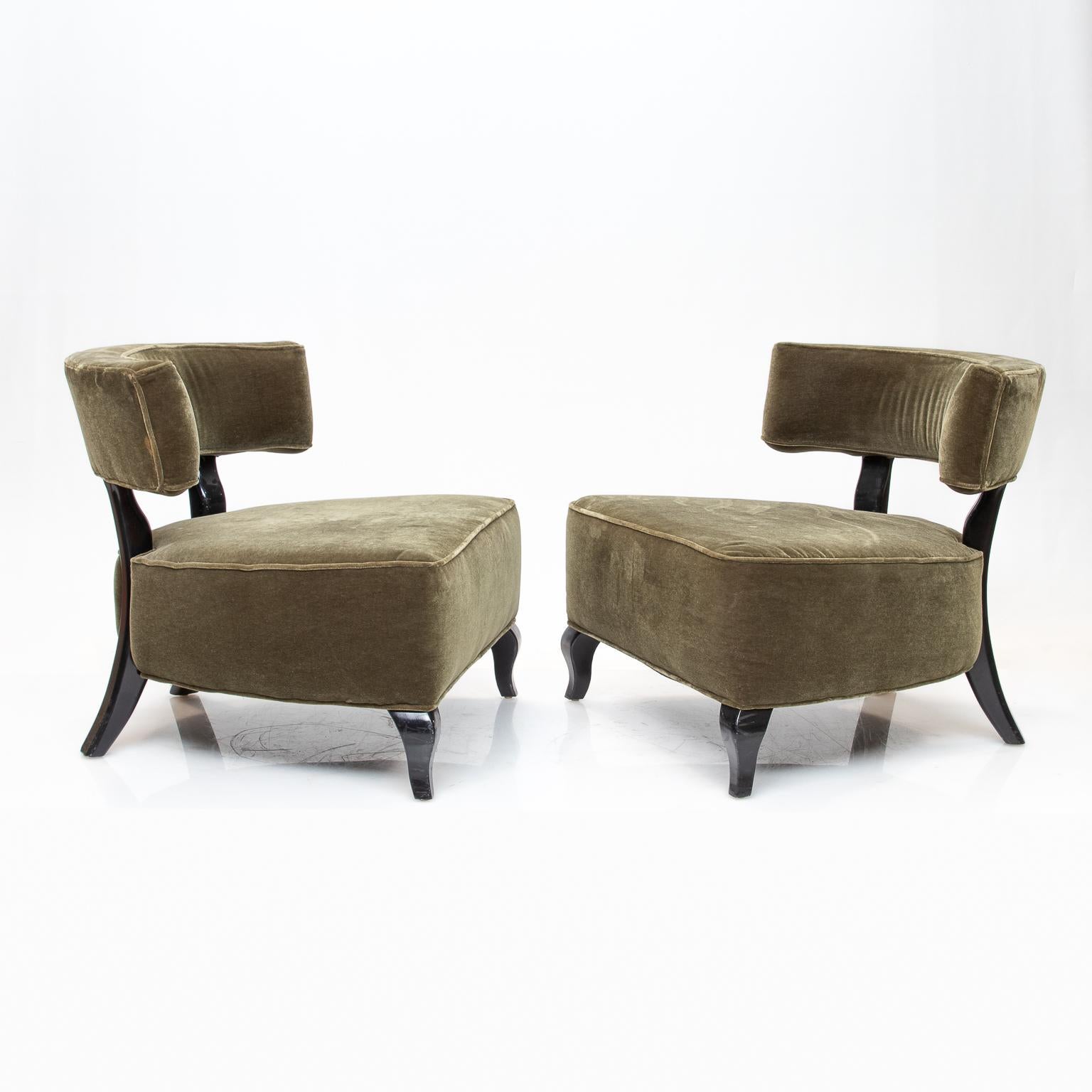 A pair of large Deco chairs in a light green mohair upholstery and black lacquered exposed wood. These chairs are very comfortable and big in appearance.