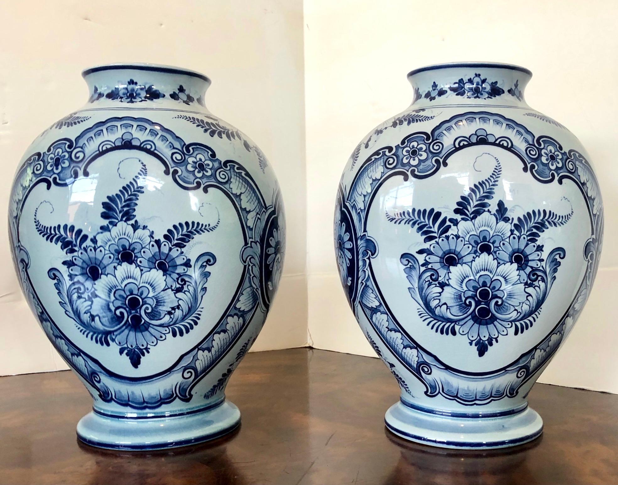 Rare pair of large antique Delft Royal Bonn German pottery faience vases circa 1890-1920. Features hand painted portraits of women on the front of urns. Signed on undersides. An unexpected surprise given the size!