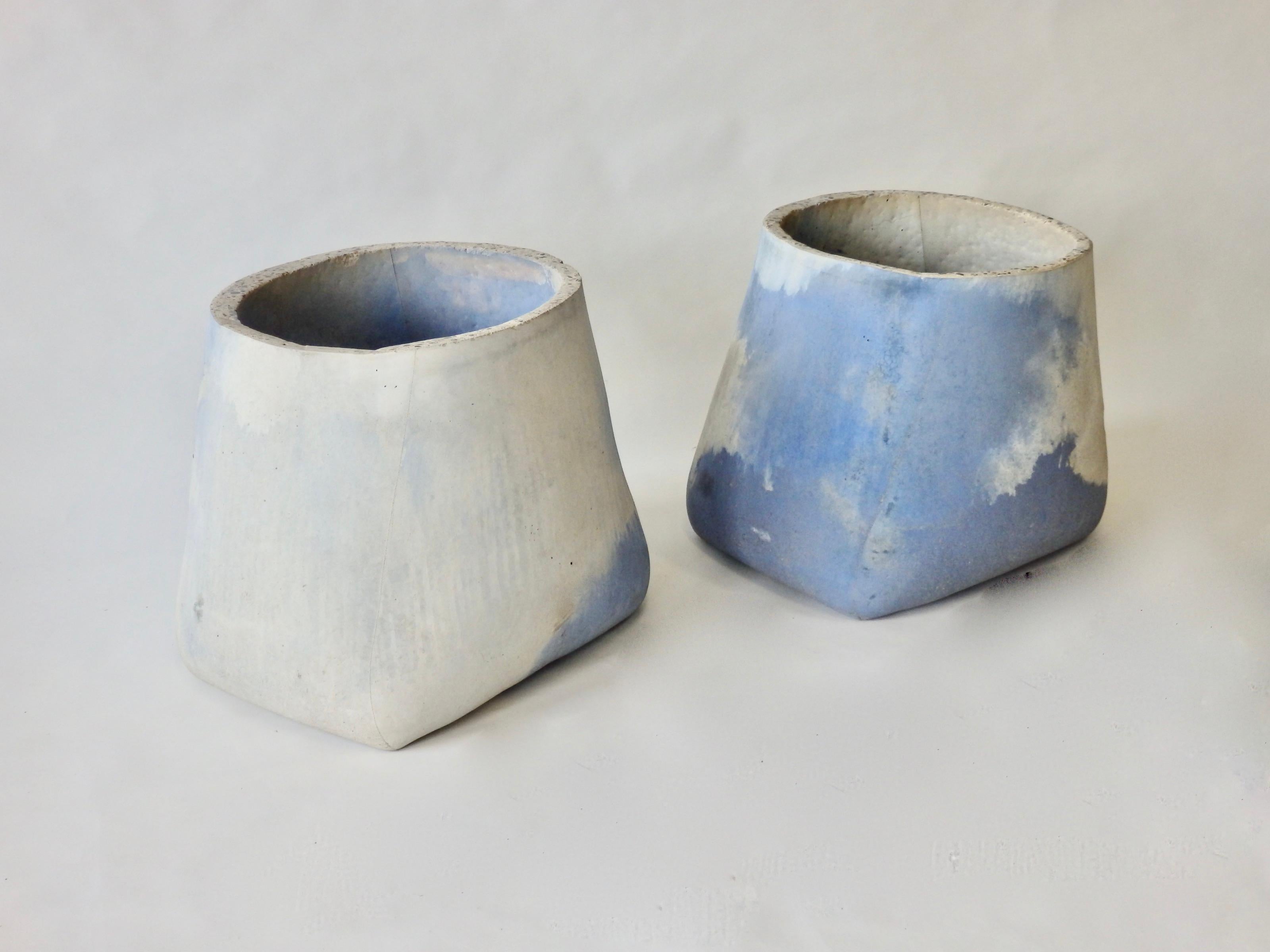 Pair of cast cement planter pots easily used as garden stools. Blue dyed and natural toned cement swirl together to create one of a kind garden art . Quite heavy .