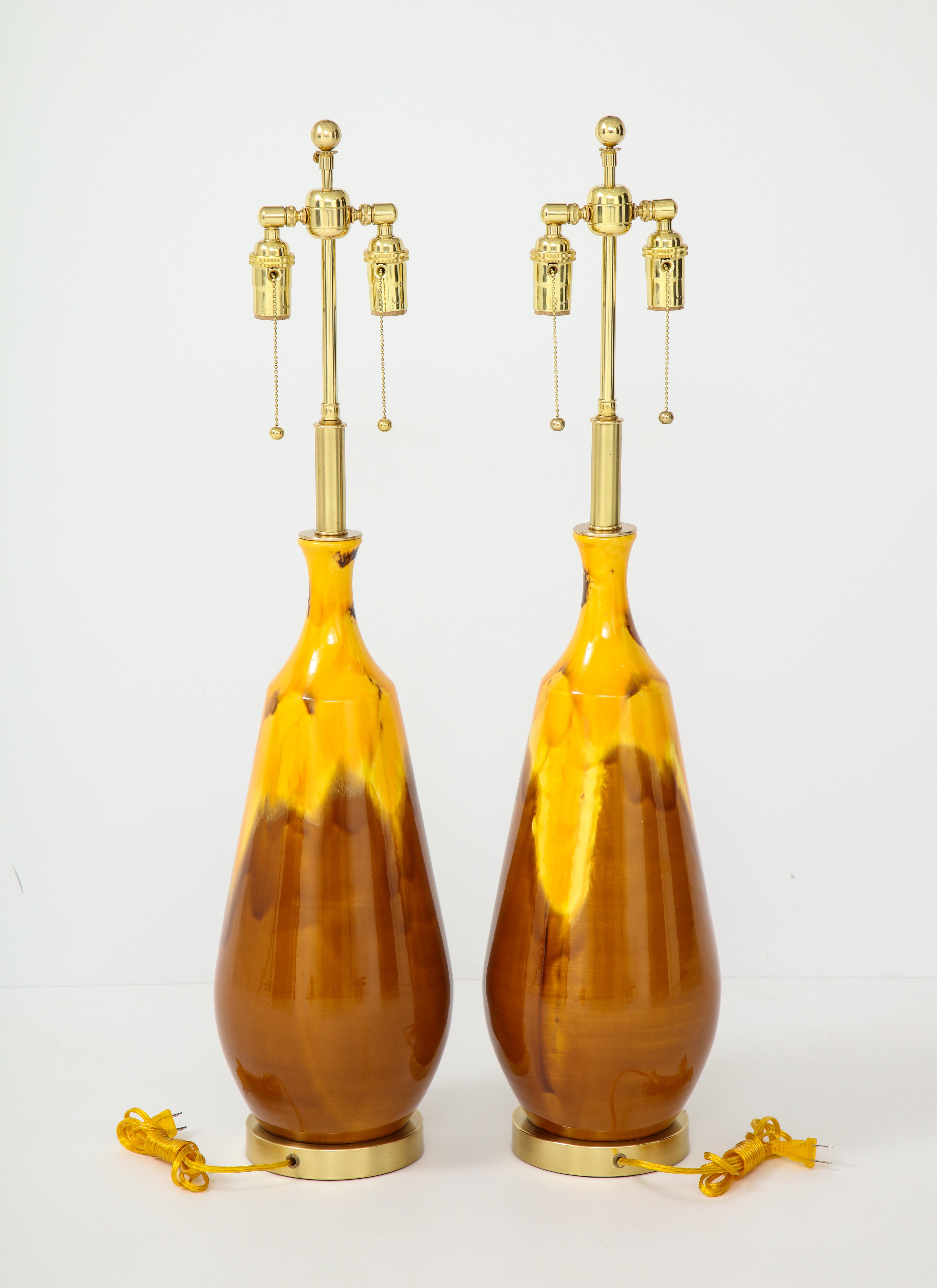Pair of large ceramic lamps with a drip glazed finish.
The lamps have been newly rewired with polished brass fittings.
