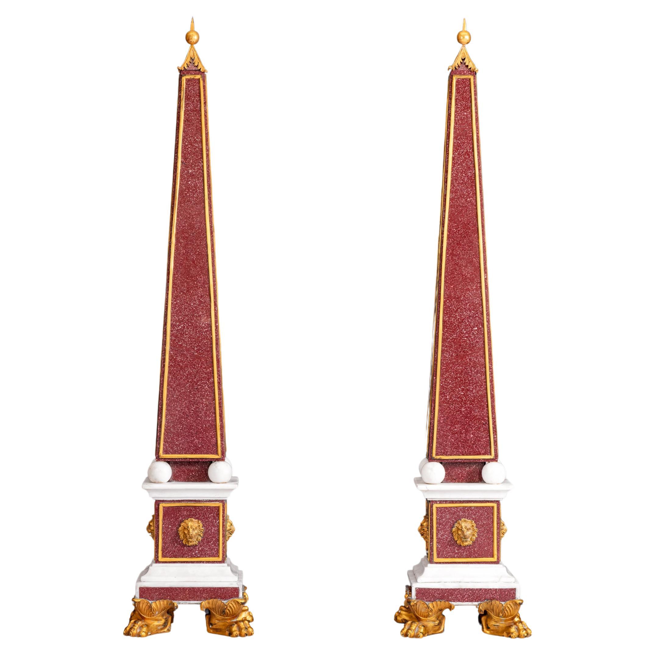 An exceptional pair of Porphyry, marble and ormolu mounted Obelisks, of typical form surmounted with foliate-cast finial above ball feet, resting on a panelled plinth mounted with lion masks and a square stepped plinth base, on foliate-wrapped paw