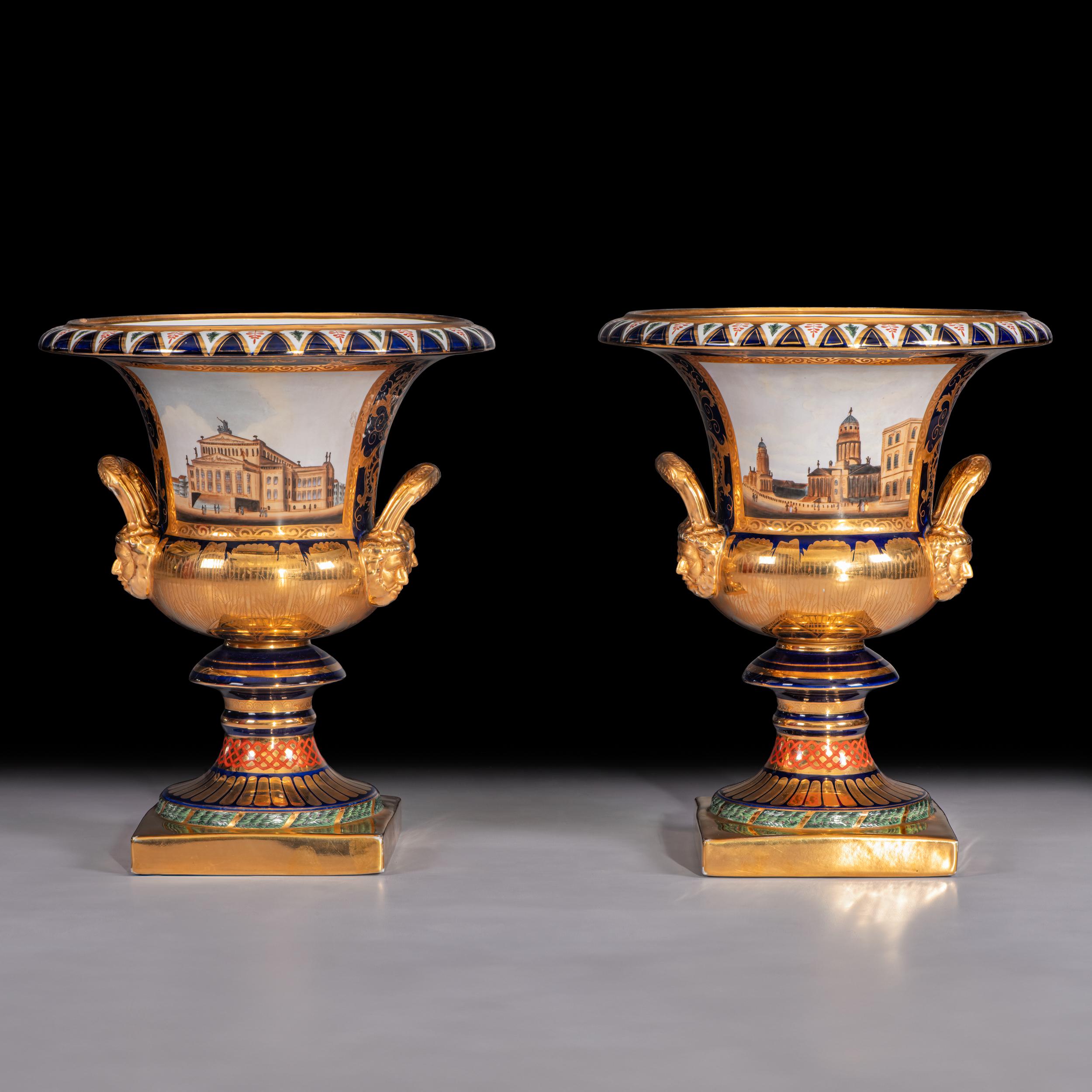 A very fine pair of French Sevre style porcelain campagna urns of large proportions, each vase bears the image of the Schauspielhaus in Berlin on one side and the image of the French Berlin Cathedral on the other side, on a cobalt blue and gilt