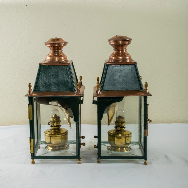 Used on the Paris-Lyon-Marseille railway, this pair of early twentieth century French copper and iron railroad lanterns feature their original brass oil lamps and inserts with glass chimneys. The lamps are marked by the maker PLM H. Luchaire 27 Rue