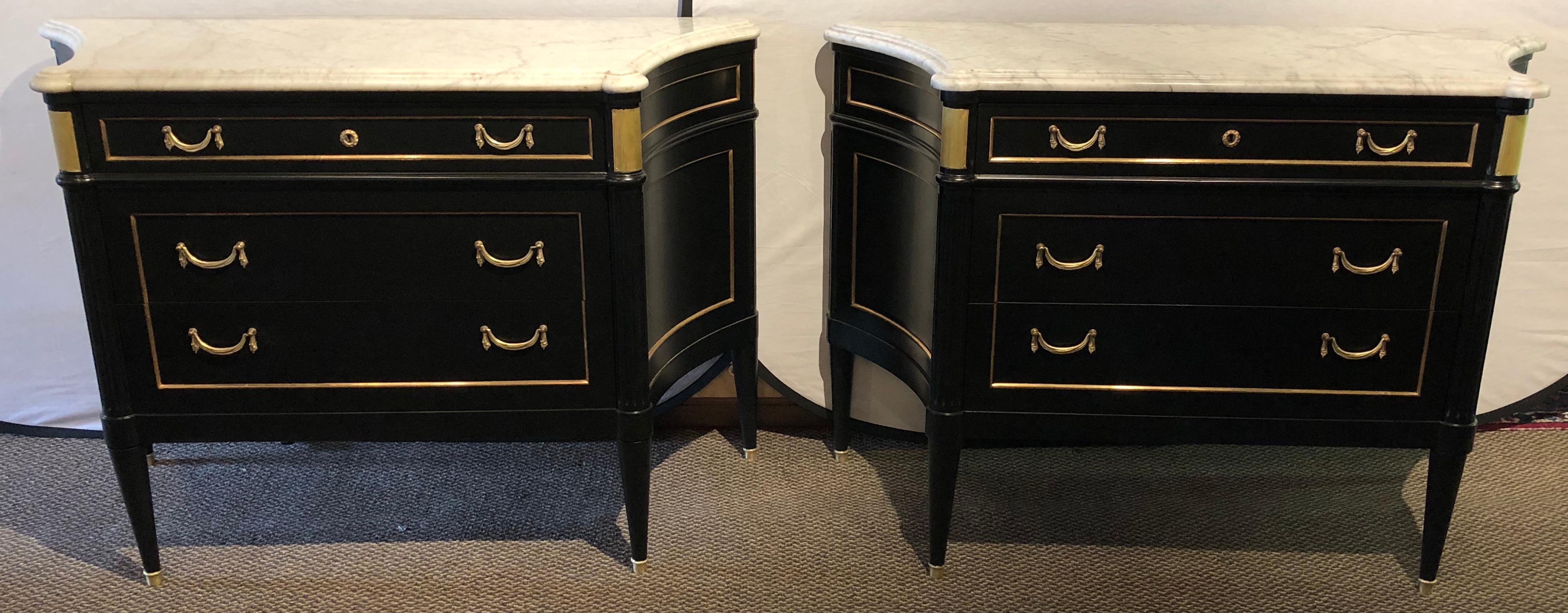 Pair of concave side large and impressive commodes, chests or nightstands in an ebony finish with marble tops and bronze mounts, attributed to Maison Jansen. Each of this stunning commodes support a thick white and gray veined marble top with