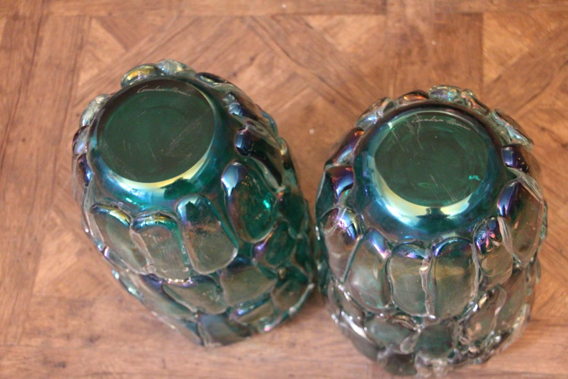 This spectacular pair of vases has got a very unusual iridescent color that goes from deep emerald green to a kind of turquoise blue according to surrounding colors and light.
Moreover they were entirely made by hand in Venice thanks to a very