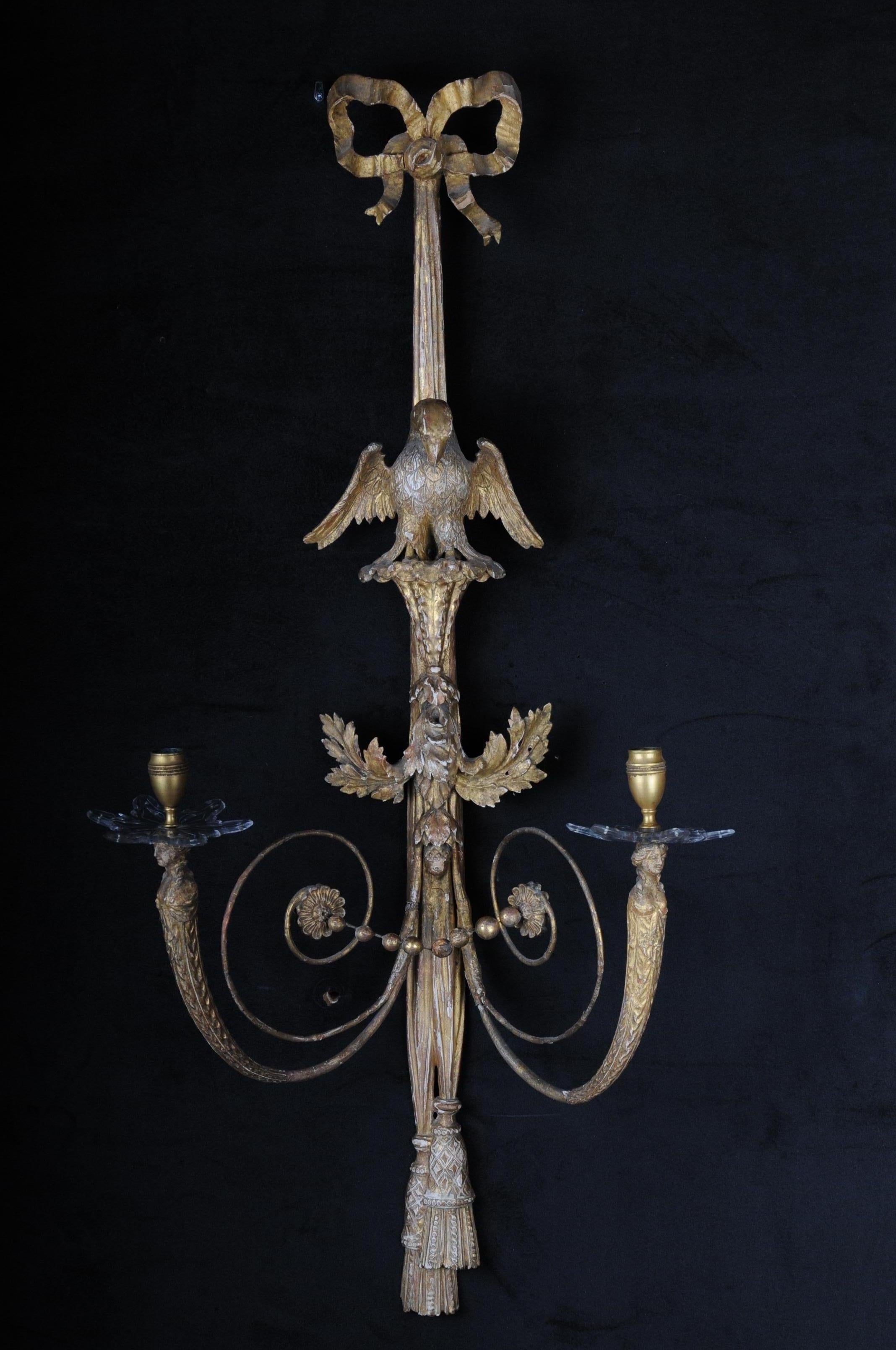 Pair of large Empire appliqués / sconces circa 1800, gilded linden wood

Solid linden wood, gilded two-flame. Carved, gilded. Ribbon, each with a central, fully sculpted eagle sculpture. Volutes light arms, ending in female busts. Candle spouts