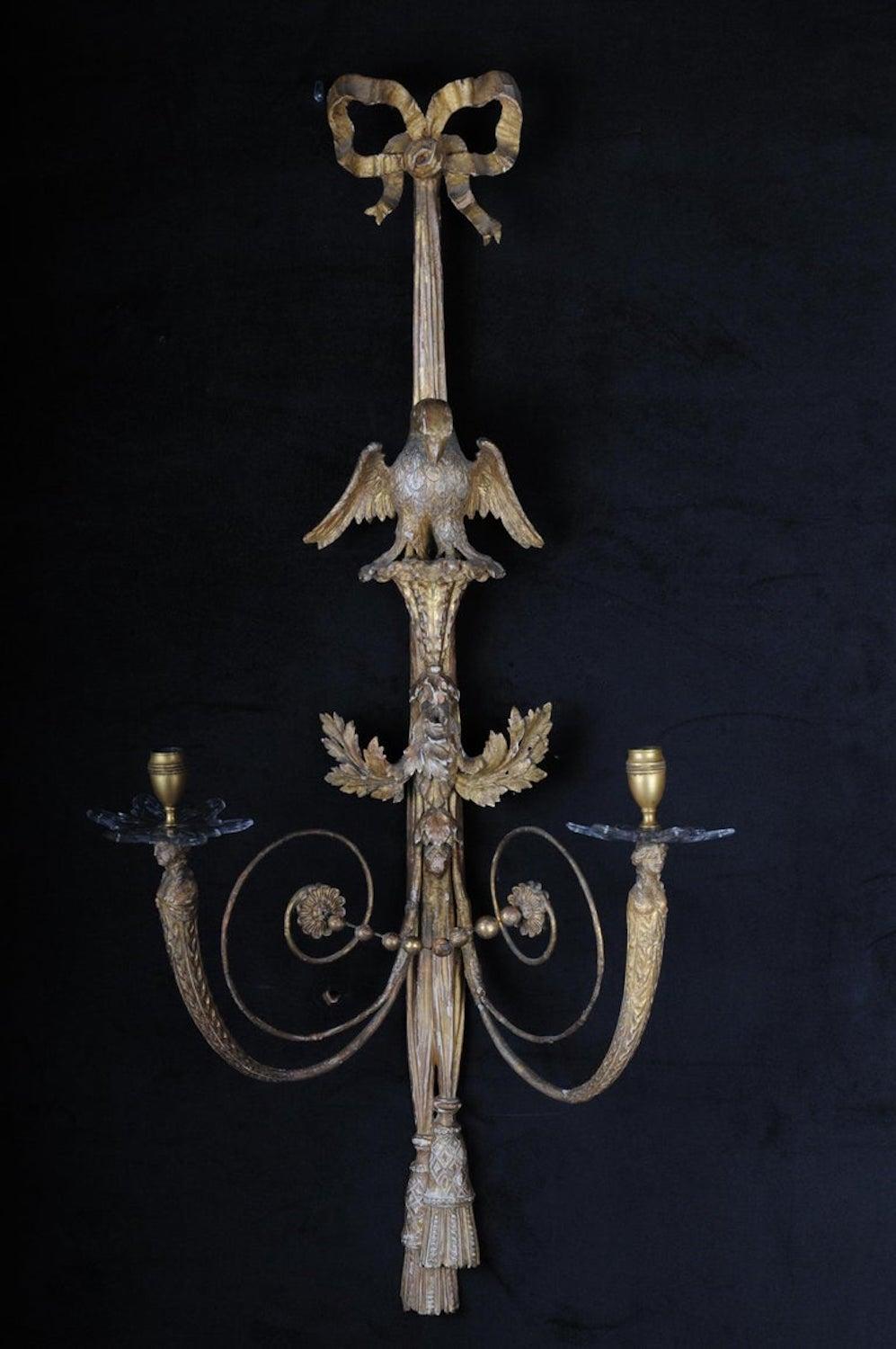 Pair of large Empire appliqués / sconces circa 1800, gilded linden wood

Solid linden wood, gilded two-flame. Carved, gilded. Ribbon, each with a central, fully sculpted eagle sculpture. Volutes light arms, ending in female busts. Candle spouts with