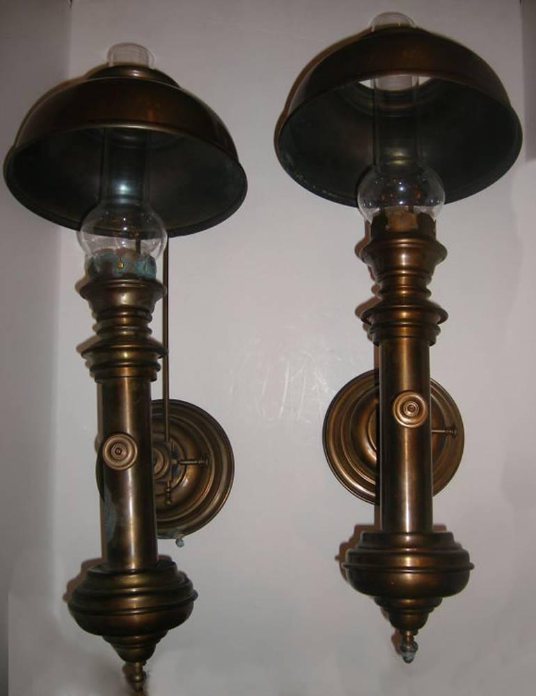 Pair of large English patinated brass sconces with adjustable shades, single light.