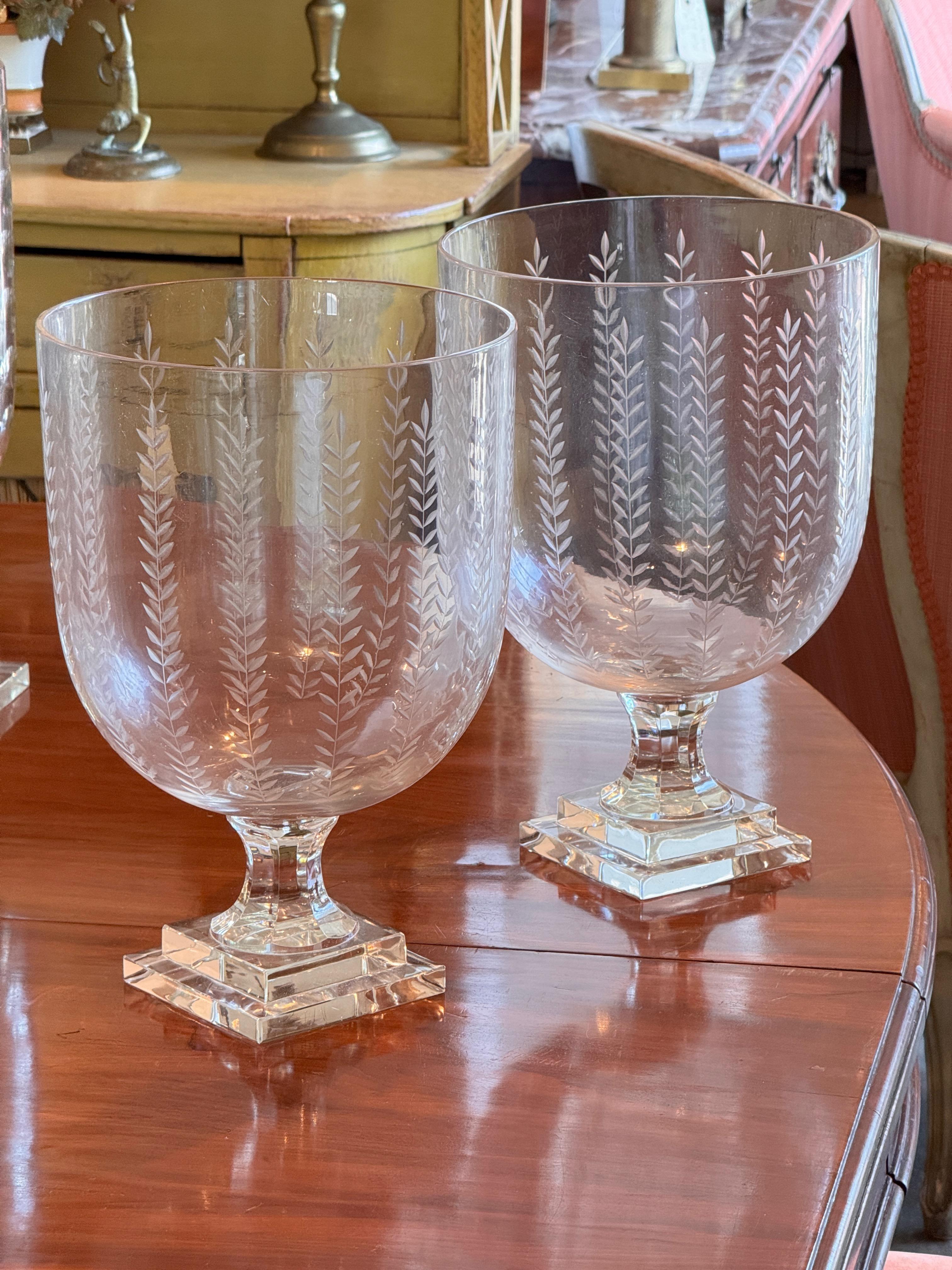Pair of tall clear glass vases etched with a vertical wheat sheaf pattern. Each stands on a stepped square base and features a deep bowl form, ideal for display or floral arrangements. Elegant and symmetrical with classic detailing.