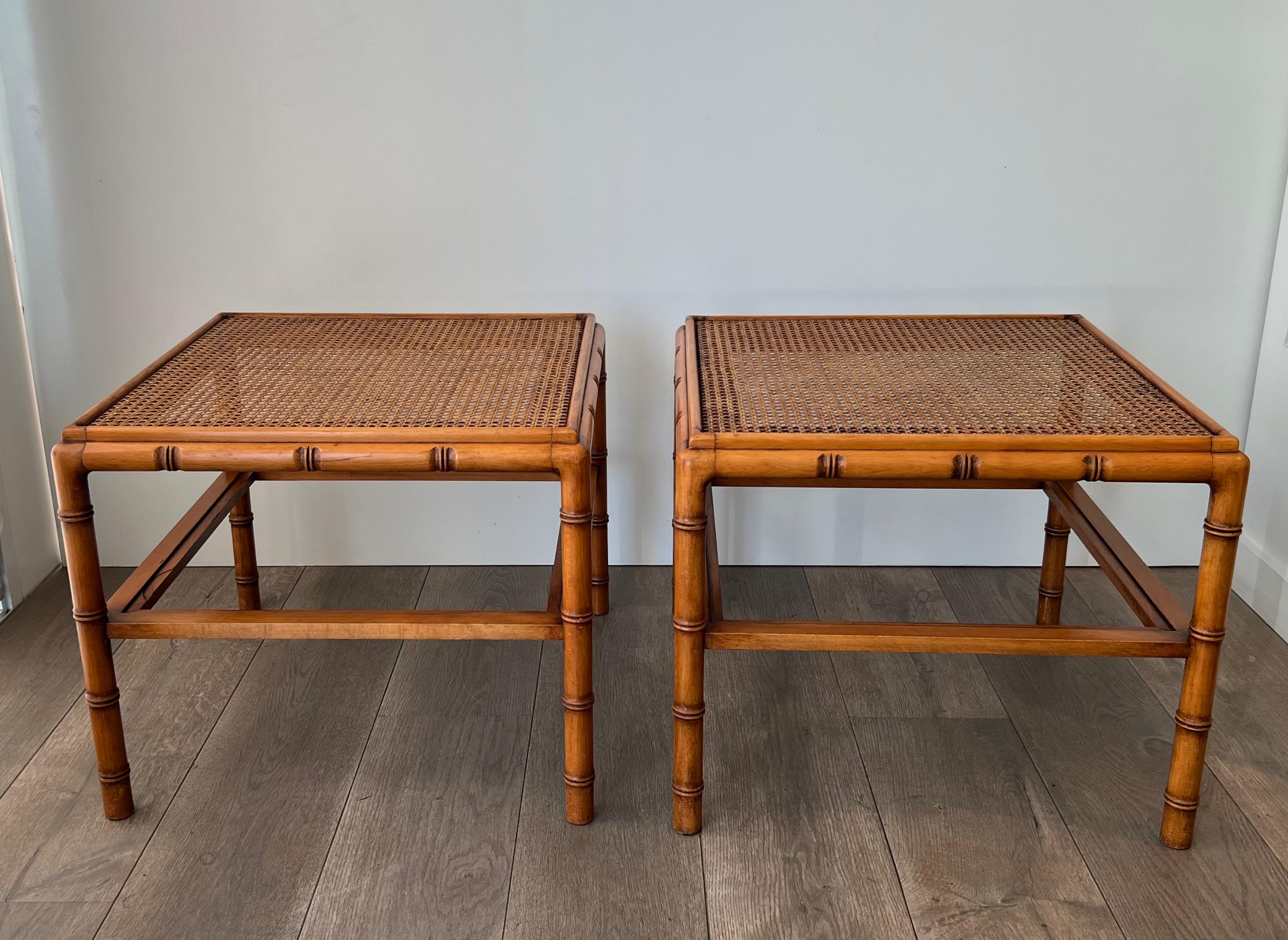 This nice and decorative pair of large faux-bamboo side tables is made of wood with glass tray on the bottom part and caned trays on top. This is a French work. Circa 1970
