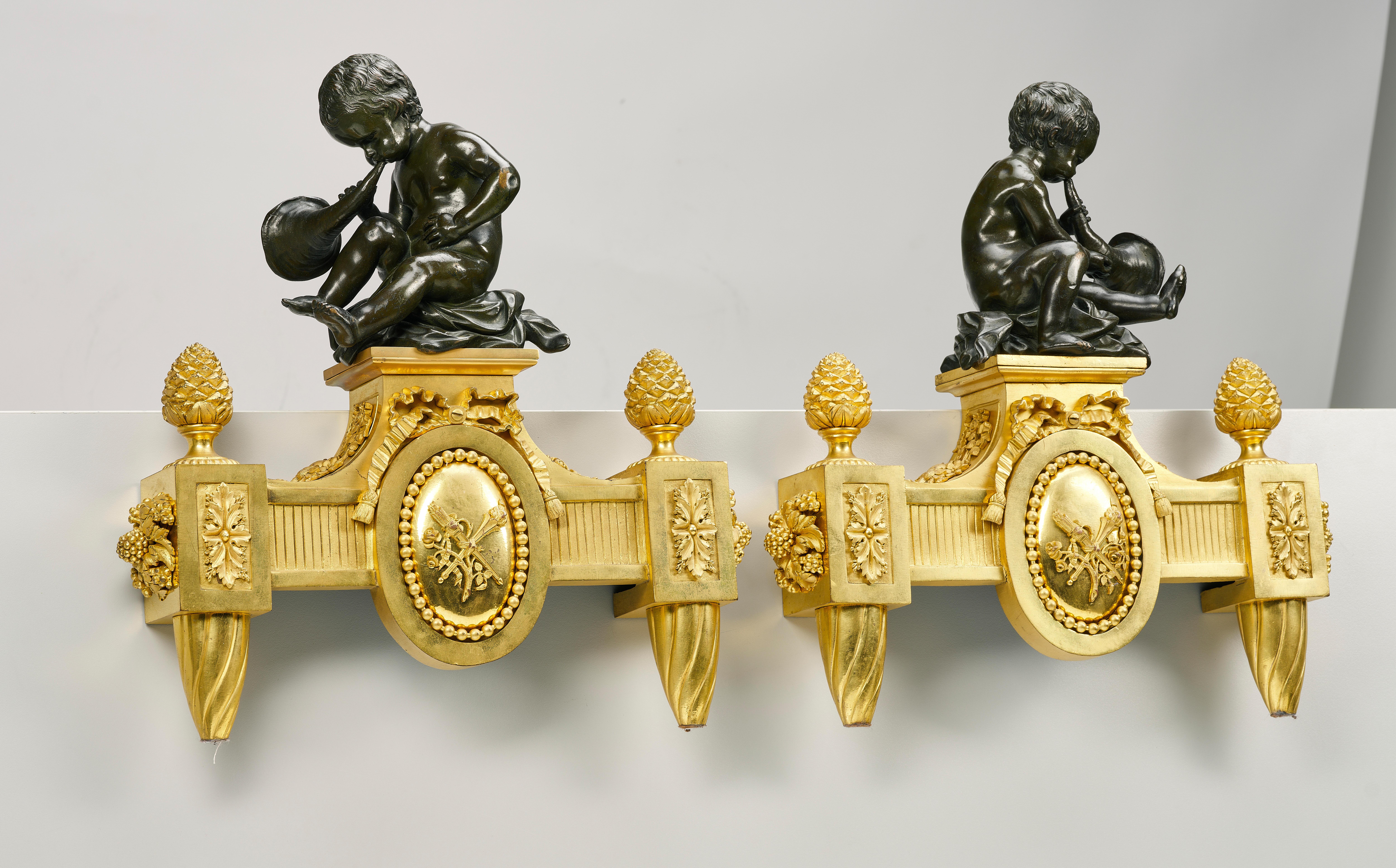 Pair of large Louis XVI style andirons, France, second half of the 19th century.
Bronze shafts in the form of trumpeting putti, topped with pine cones, with central medallions and ornamental decoration of fine quality. Partially patinated with