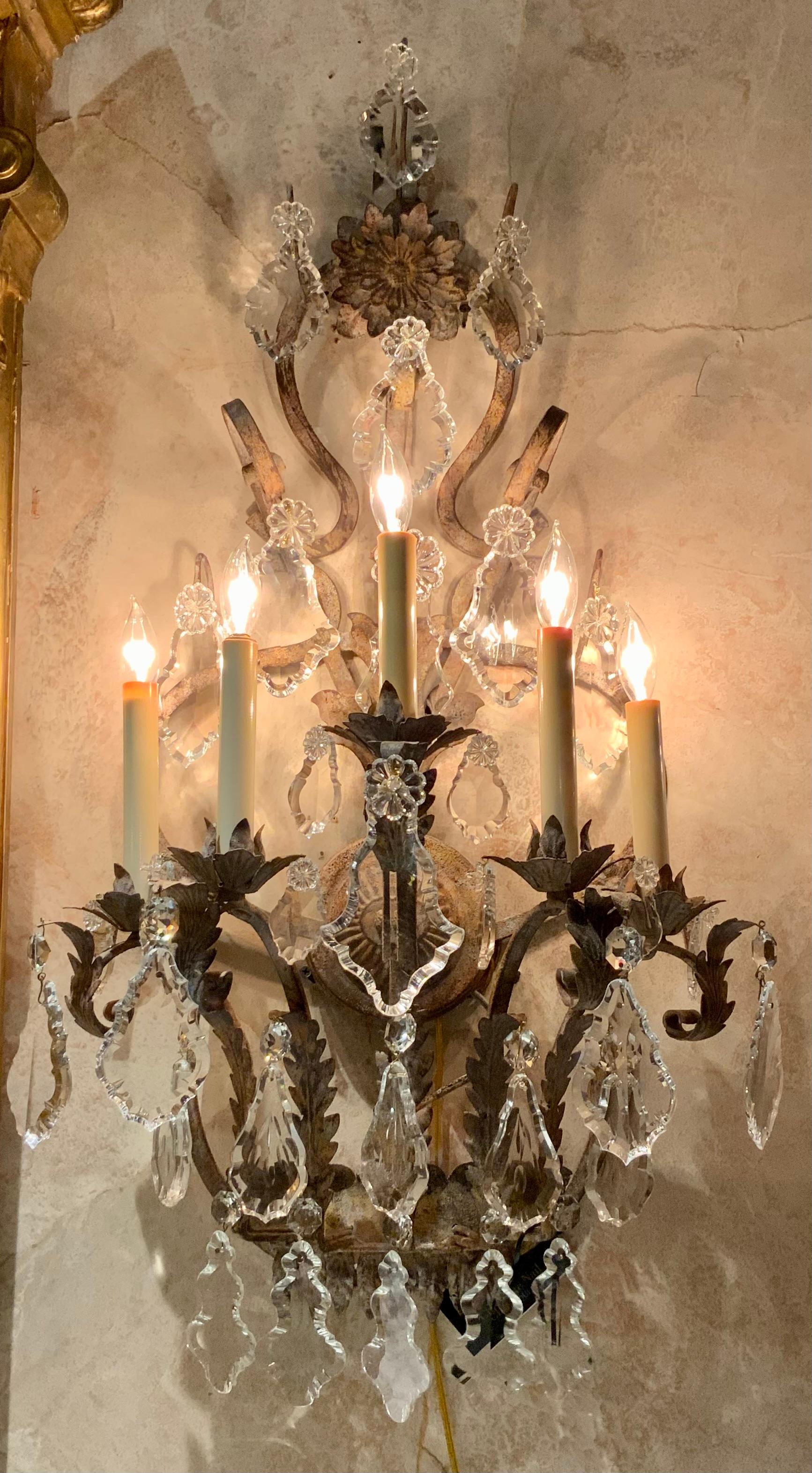 The unique shape of this piece is special with an antique
Painted finish in a rustic fashion. They have new wiring
With five lights in a graduated position supported by scrolling
Arms. A large floral design is positioned at the crest. The
Crystal is