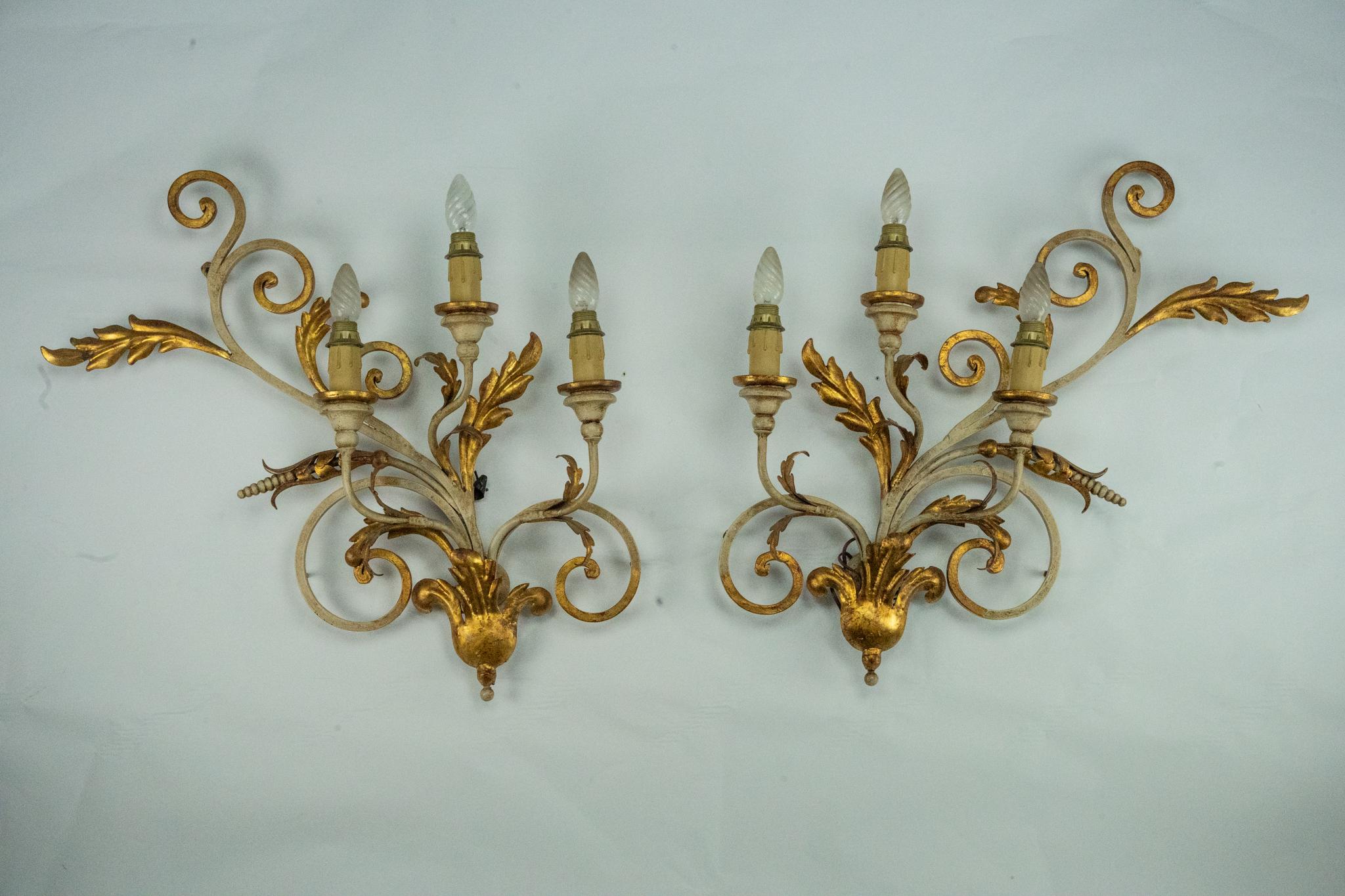 Coppia di grandi lampade da parete floreali in metallo dorato e laccato, realizzate in Italia negli anni Sessanta. Ogni applique è riccamente decorata con eleganti Branch e foglie stilizzate, rifinite con una combinazione di oro e lacca avorio. Il