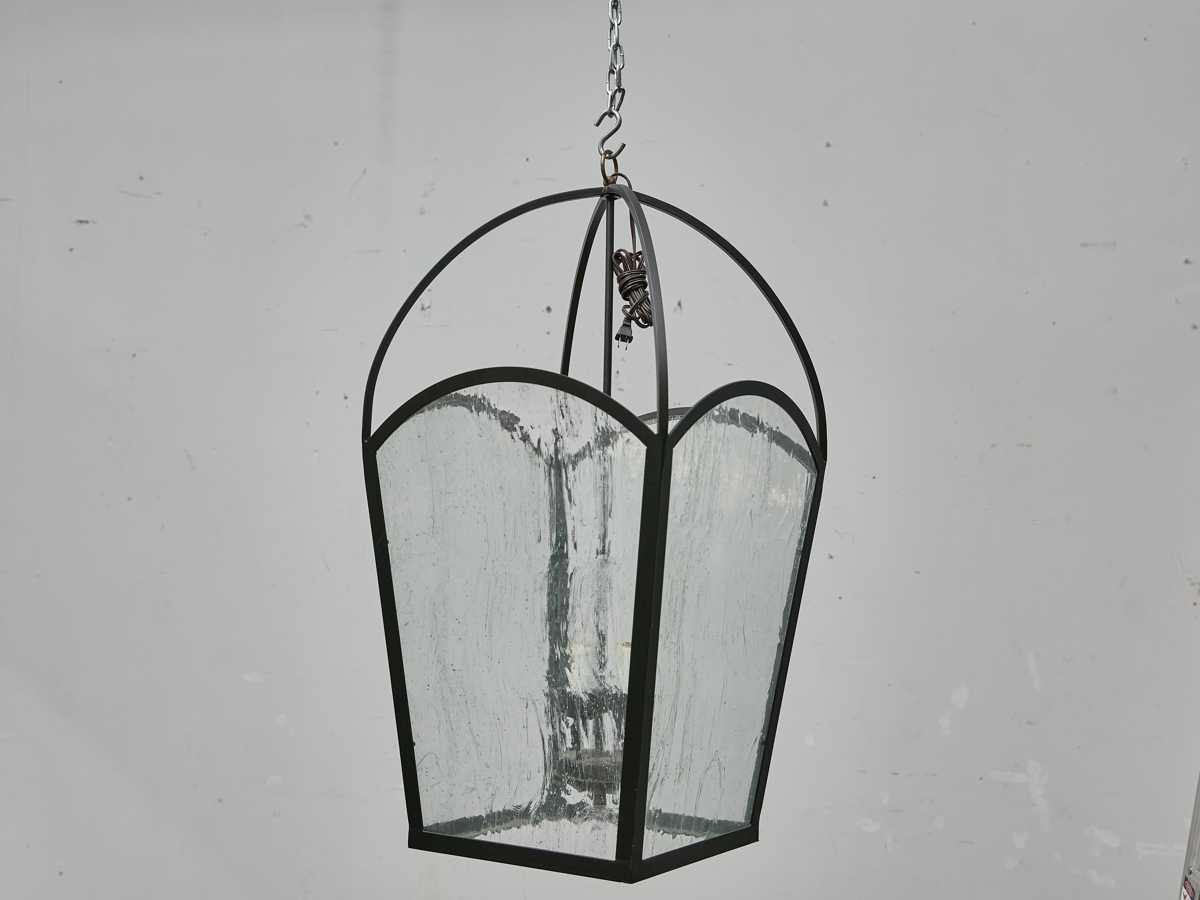 Paire de grandes lanternes françaises en fer, vers 1900, présentant un verre soufflé à la main avec une texture ondulée qui ajoute un mouvement subtil et de la profondeur au design. Chaque lanterne est équipée de quatre lumières intérieures