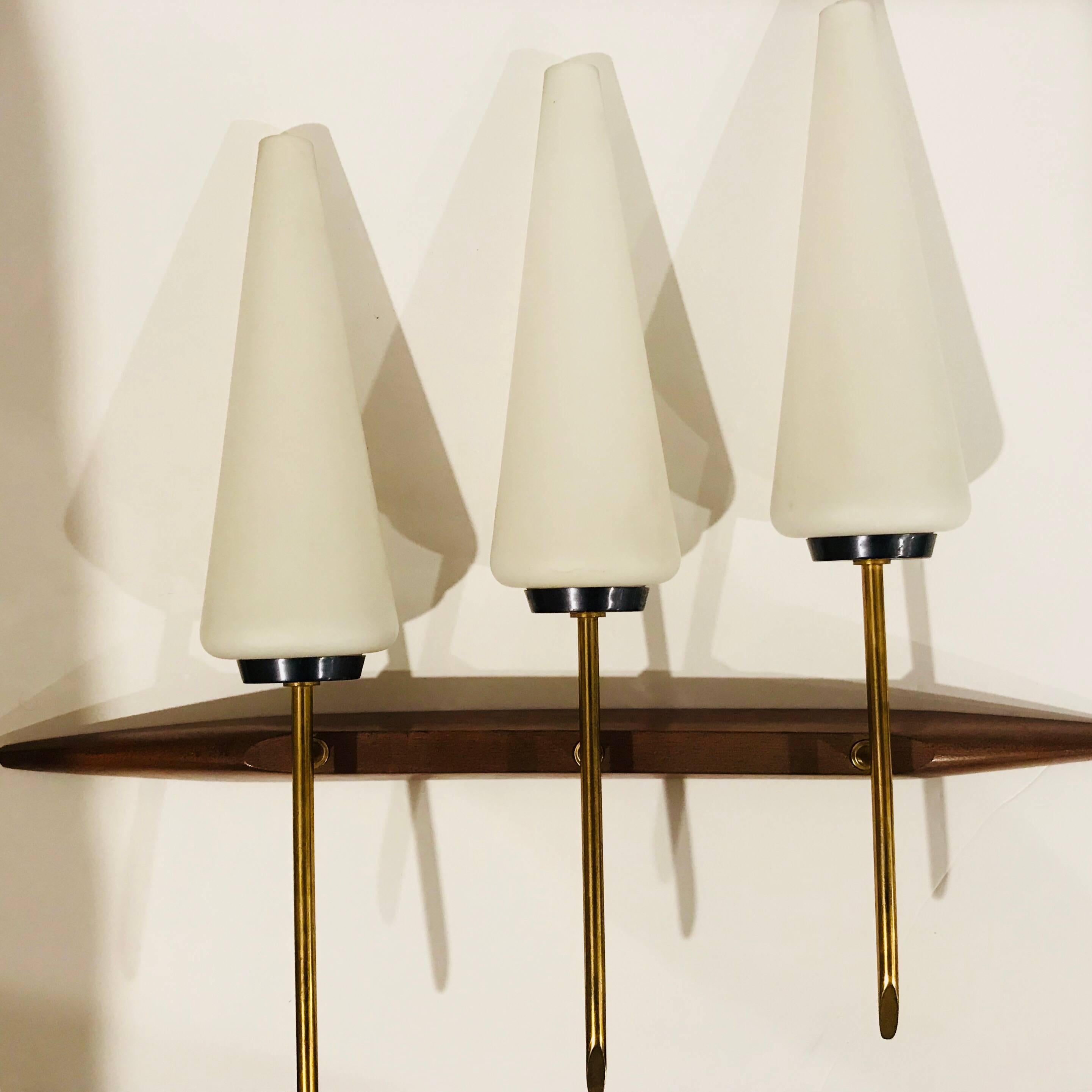 Maravillosa pareja de grandes apliques franceses compuestos por cuerpos de teca, latón pulido y esmalte de metal de cañón con pantallas cónicas de cristal blanco. Recién recableadas, cada una con una toma de candelabro.