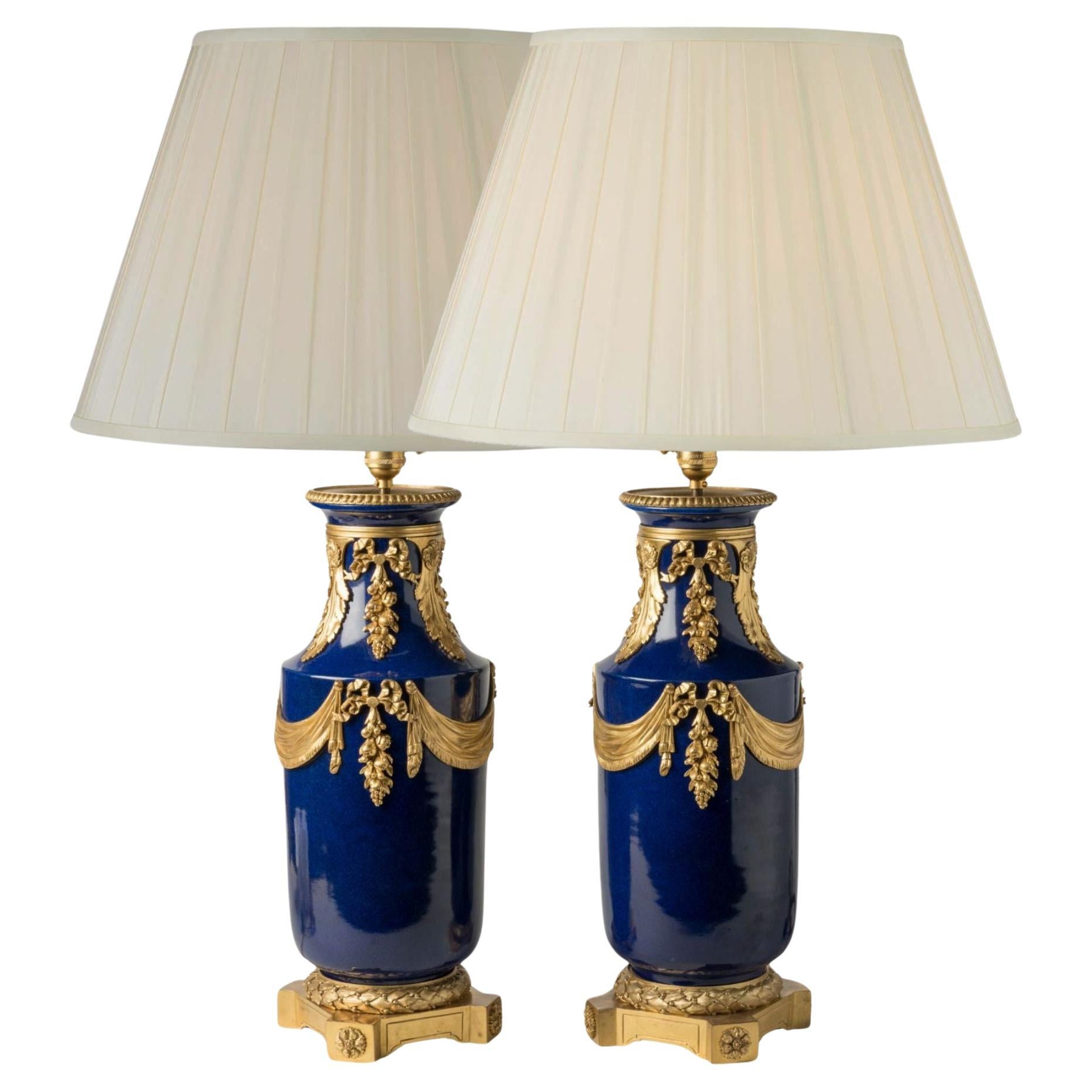 Paire de grandes lampes anciennes en porcelaine bleue de France avec montures en bronze doré en vente