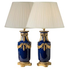 Paire de grandes lampes anciennes en porcelaine bleue de France avec montures en bronze doré