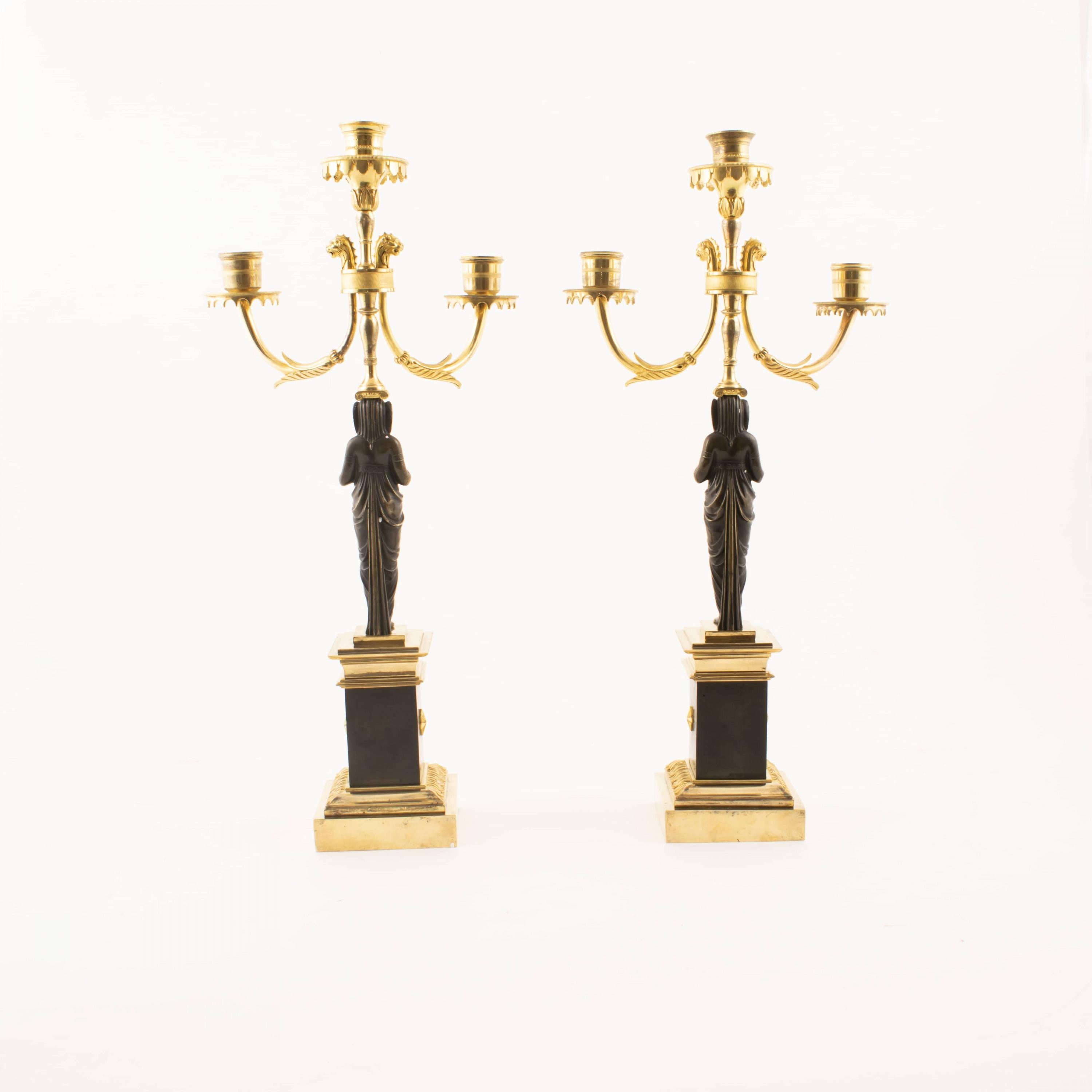A pair of Empire candelabra in gilded and dark patinated bronze.
3 Light arms, stem in the form of women in light clothing.
Light pipes with chisels.
Two light stems with foliage at the top with lion's heads below cuffs, wavy border.
Originally used