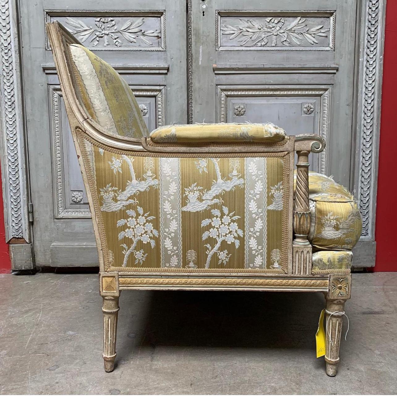 A large pair of French Louis XVI bergeres that are called marquis in France due to their extra width to accomodate ladies wide gowns. These very comfortable chairs were created in the 1920's and have very nice carving with many neoclassical details,