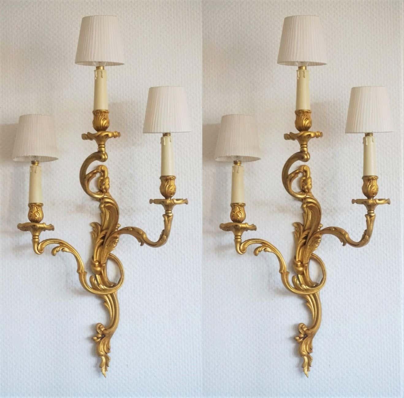 A large pair of Louis XVI style gilt bronze three-light candelabra wall sconces richly decorated with foliage, France, circa 1880-1890. Electrified at a later time. Beautiful aged patina to bronze.
Three E14 candelabra light bulb holders with