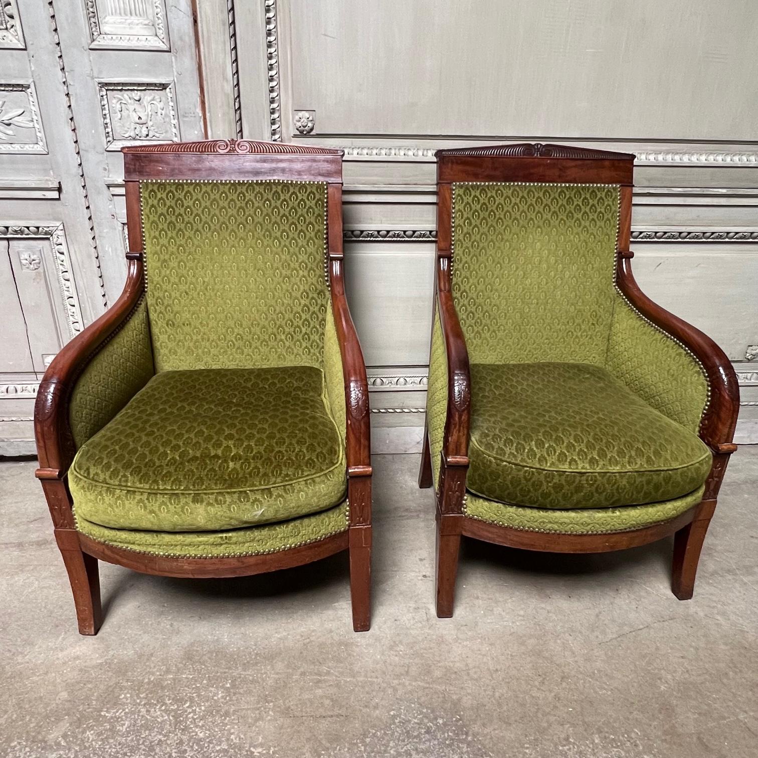 This pair of French carved mahogany Charles X beregeres, armchairs are larger than most from this period and are nicely carved and elegant with a late neoclassical style. These armchairs date from the early 19th century and appear to be solid
