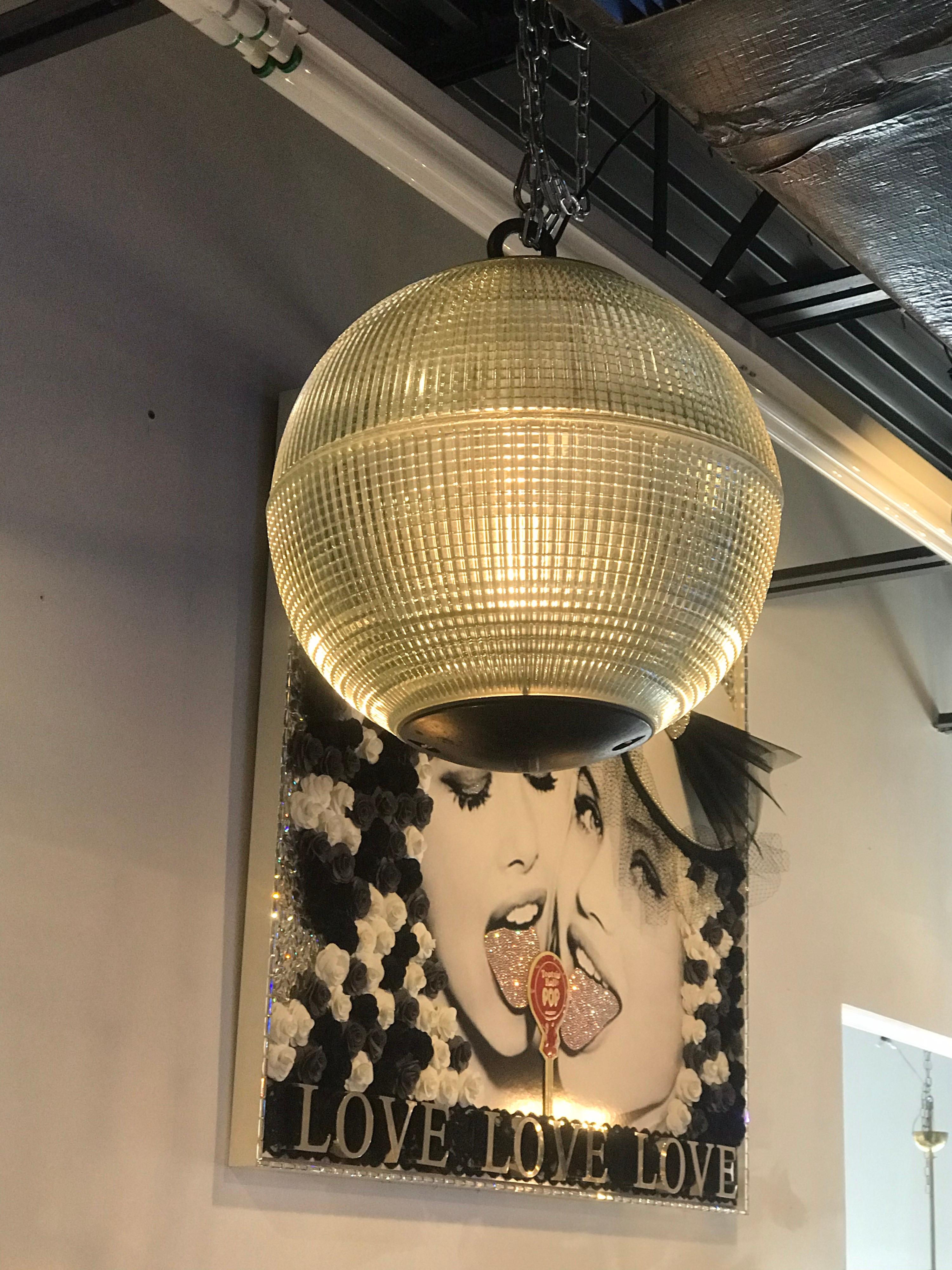 A wonderful very large spherical globe, originally a Paris streetlight and transformed into a hanging pendant. The hallmark of Holophane luminaires, or lighting fixtures, is the borosilicate glass reflector/refractor. The glass prisms or ribs