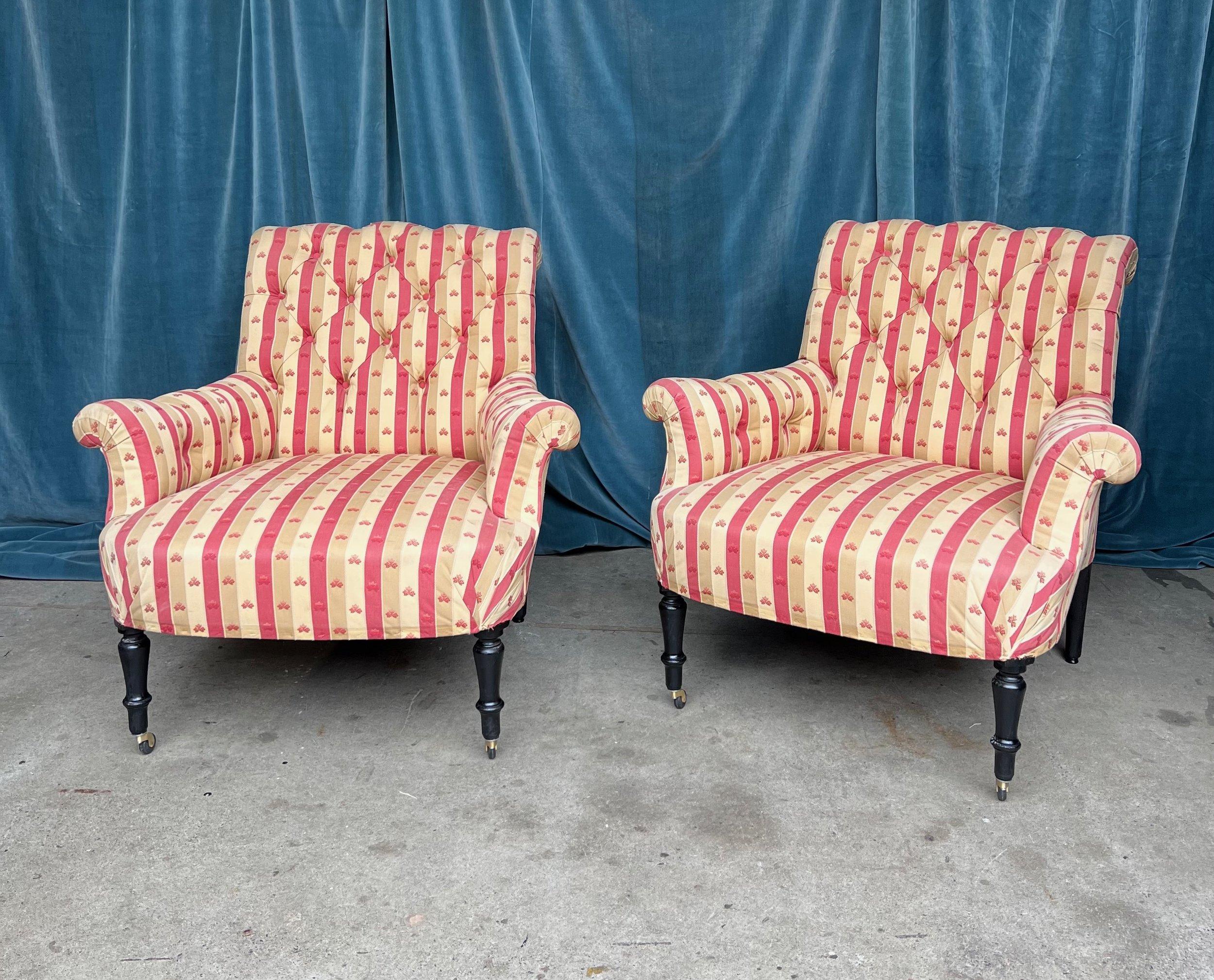 A striking pair of Napoleon III armchairs in a red and tan striped fabric. Crafted with quality and attention to detail not seen in modern-day furniture, these beautiful large scale chairs will make a statement in any room. Upholstered in a classic