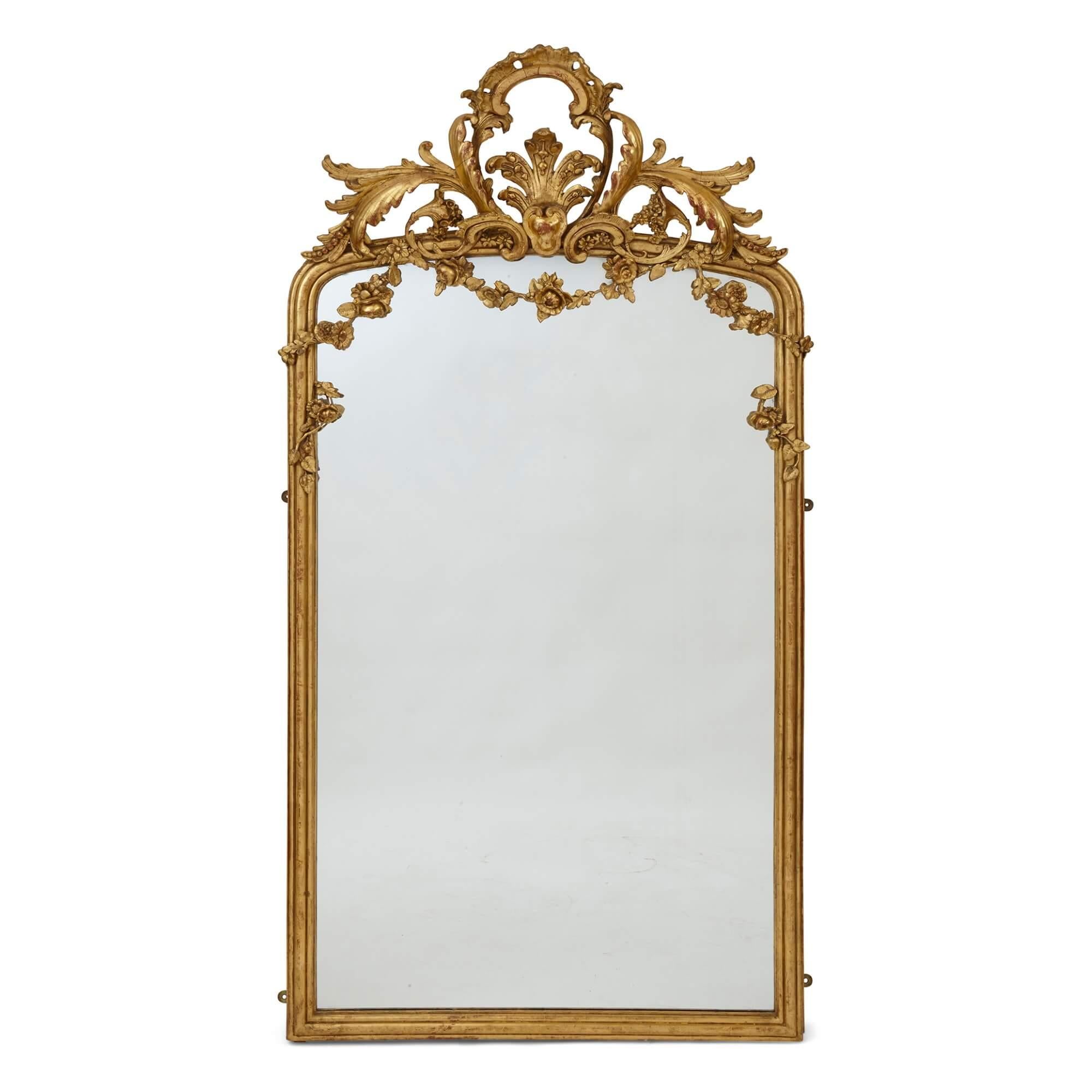 Pair of large French Rococo revival giltwood large mirrors
French, Late 19th Century
Measures: Height 187/191cm, width 98cm, depth 11cm

In a restrained, simple, yet elegant and charming Rococo revival style, this pair of large giltwood mirrors