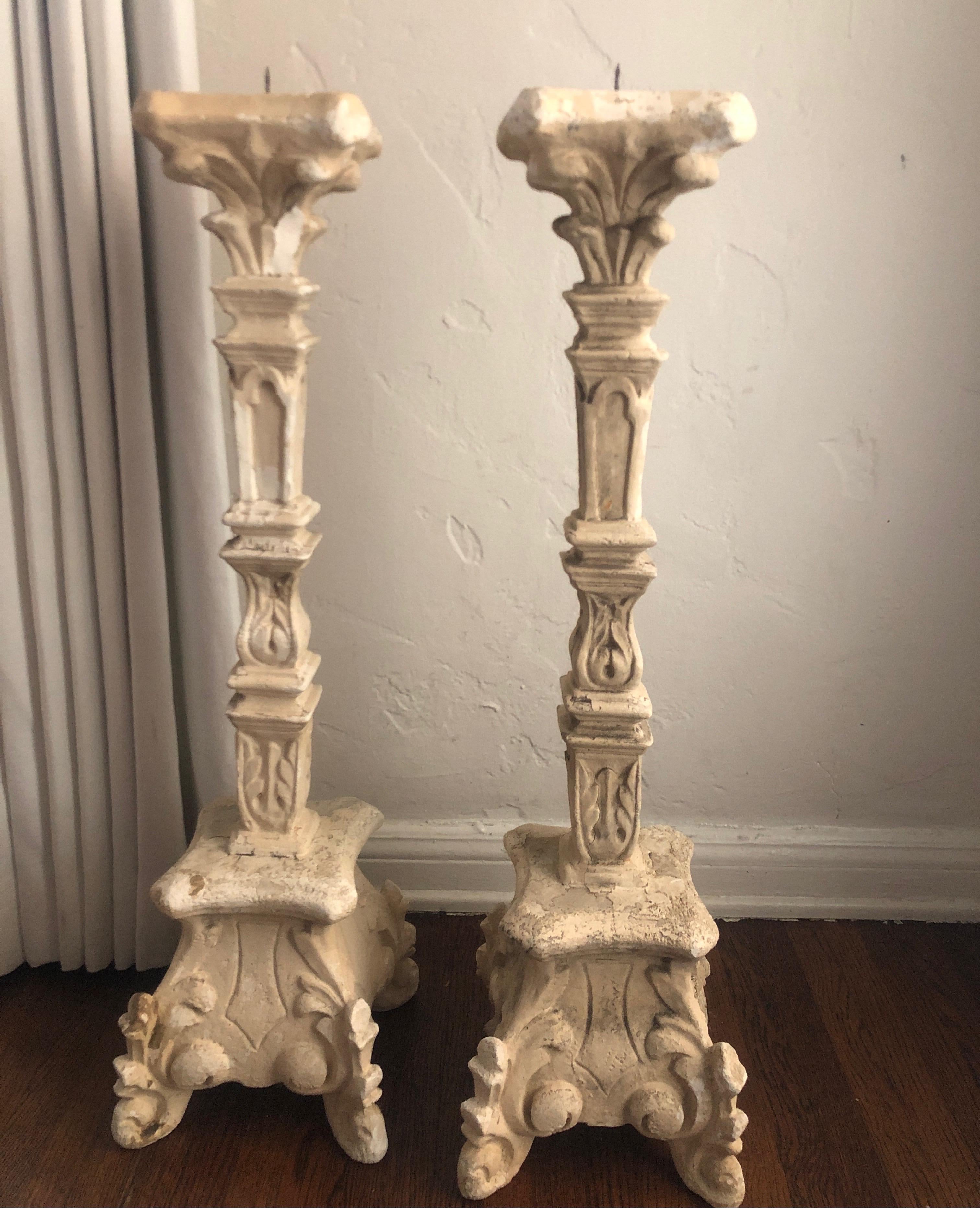 A pair of antique plaster candlesticks with large picket for single candle at the top. 
They have lots of character with loss/chips/breaks and old paint. Very eye catching with solid thick scrolling bases.  See pics

  