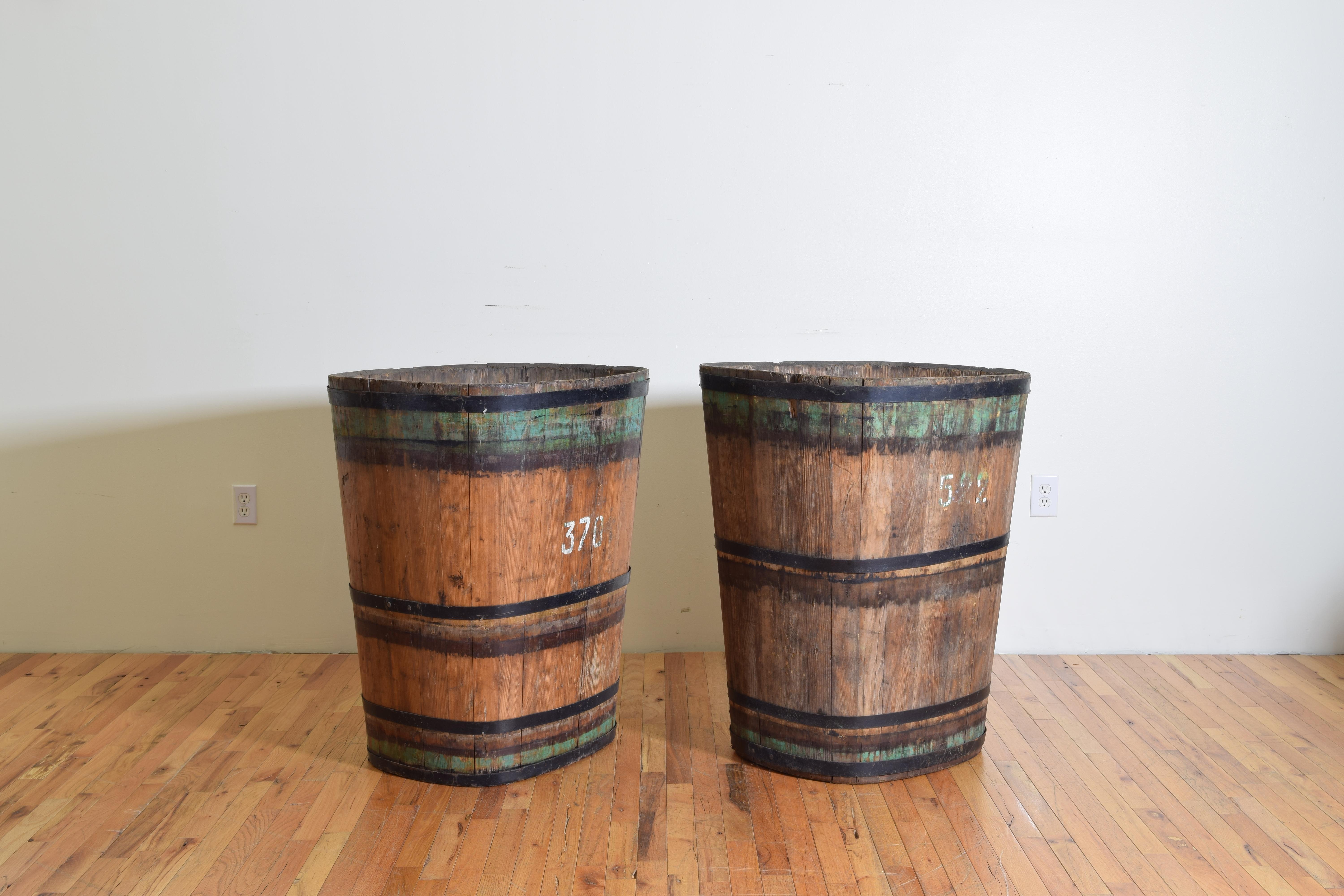 the buckets are made of multiple planks of wood bound by iron straps, retaining original paint and numbers, stenciled 
