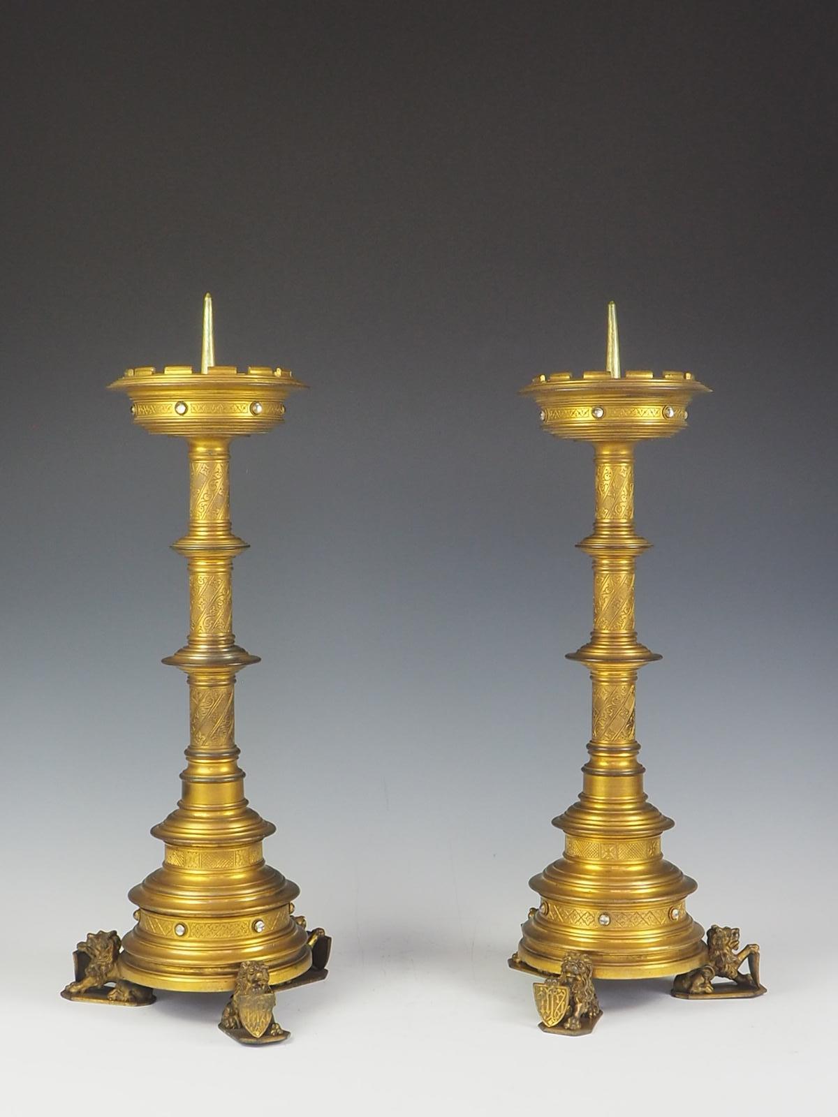 A truly exquisite 19th Century pair of gilt bronze Gothic revival Church candleholders

At the base of each candleholder there are 3 detailed lions stood proud holding shields

The candlestick shafts are beautiful detailed and cabochon stones