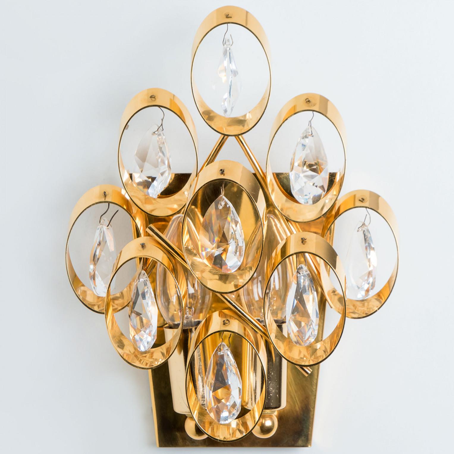 Pair of sculptural wall light has the design of a multitude of golden rings with crystals hanging and are from the historical lighting company Ernst Palme.

Dimensions:
Height: 11.81